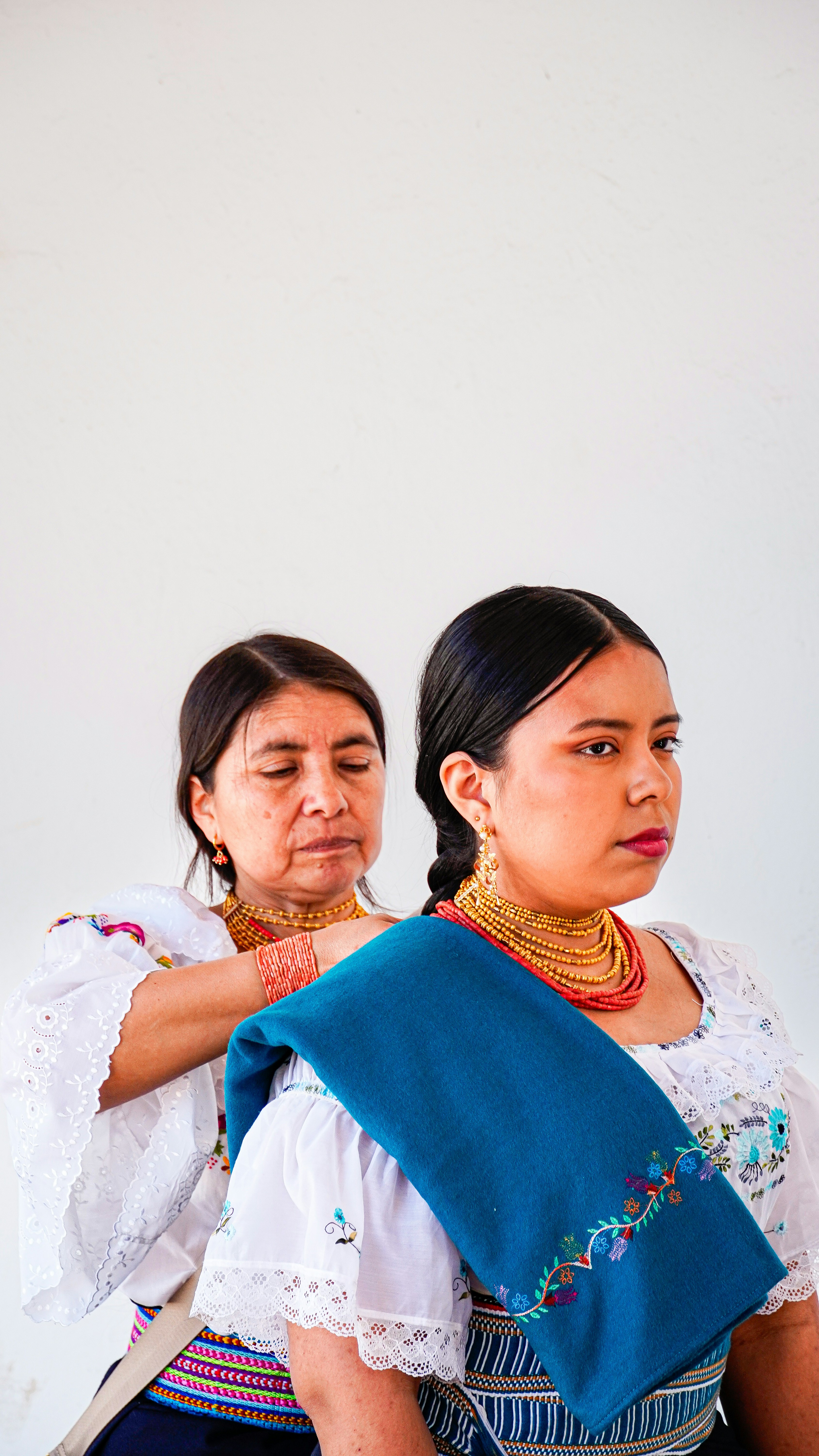 メキシコの伝統的な衣装を着た2人の女性が隣り合って立っています