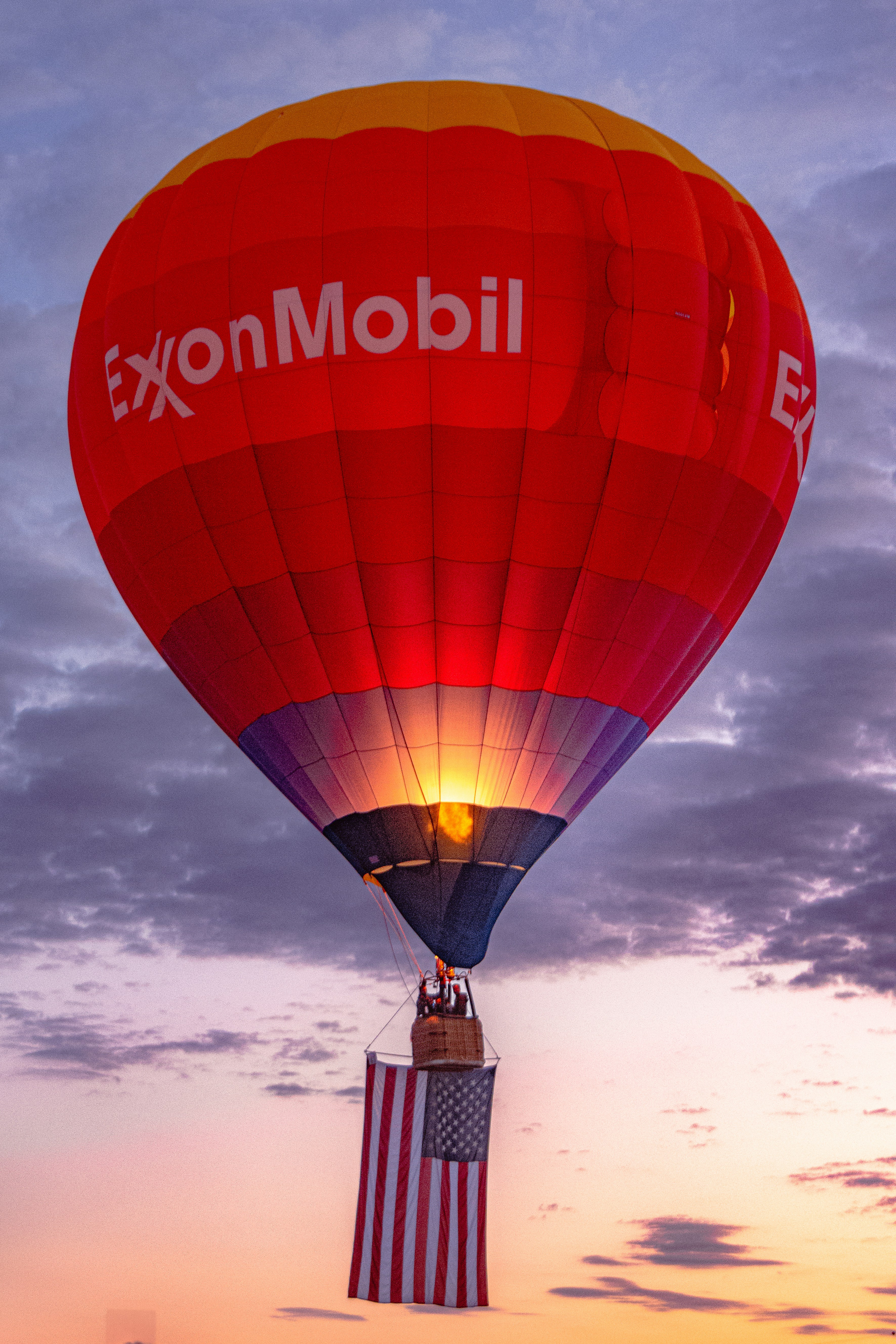 A hot air balloon with a flag hanging off of it's side