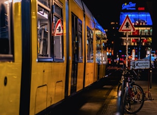 A yellow train parked next to a loading platform