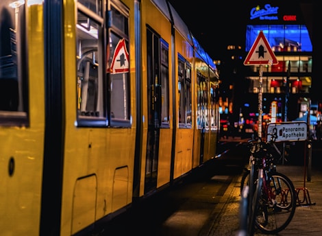 A yellow train parked next to a loading platform
