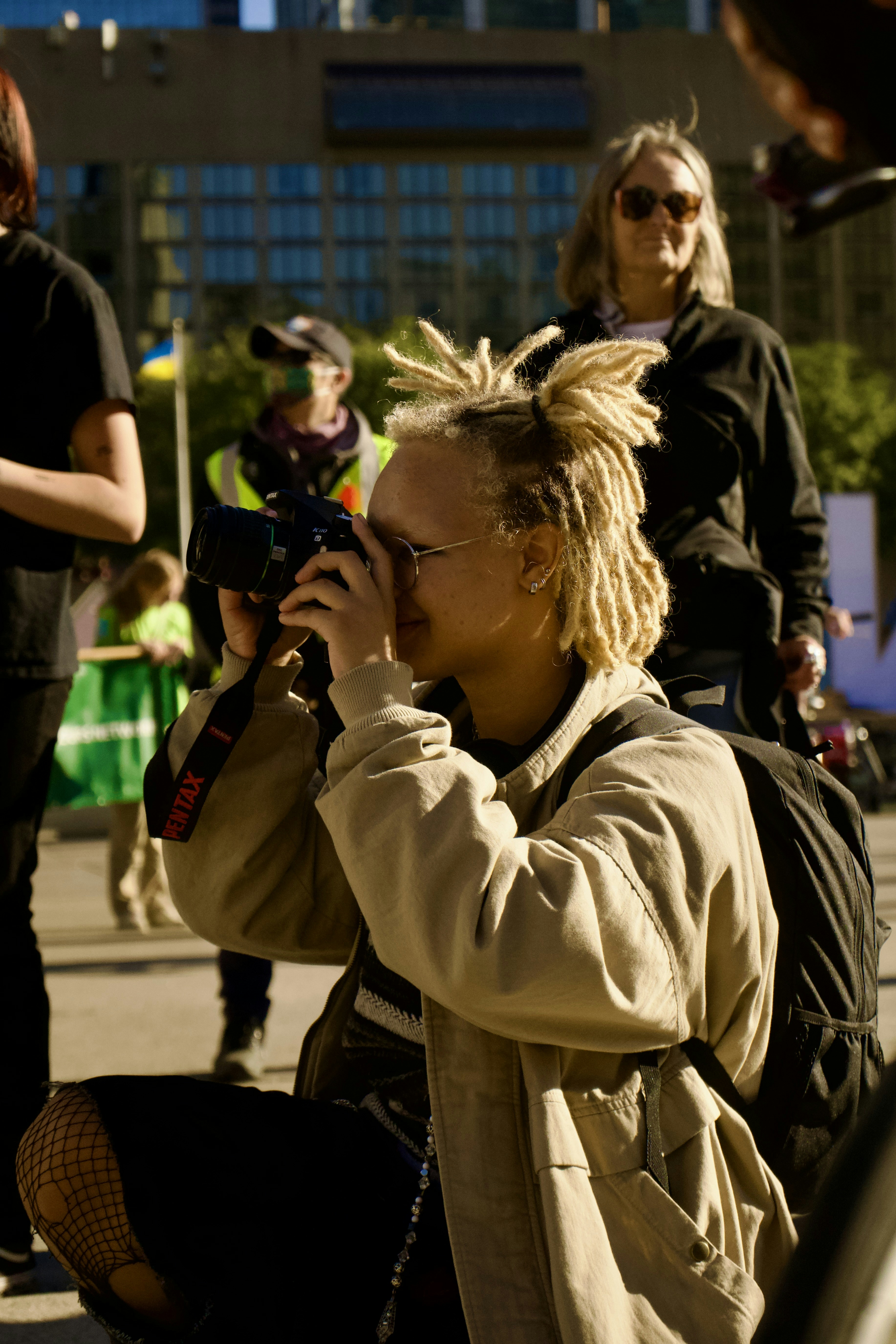 A woman sitting on the ground talking on a cell phone