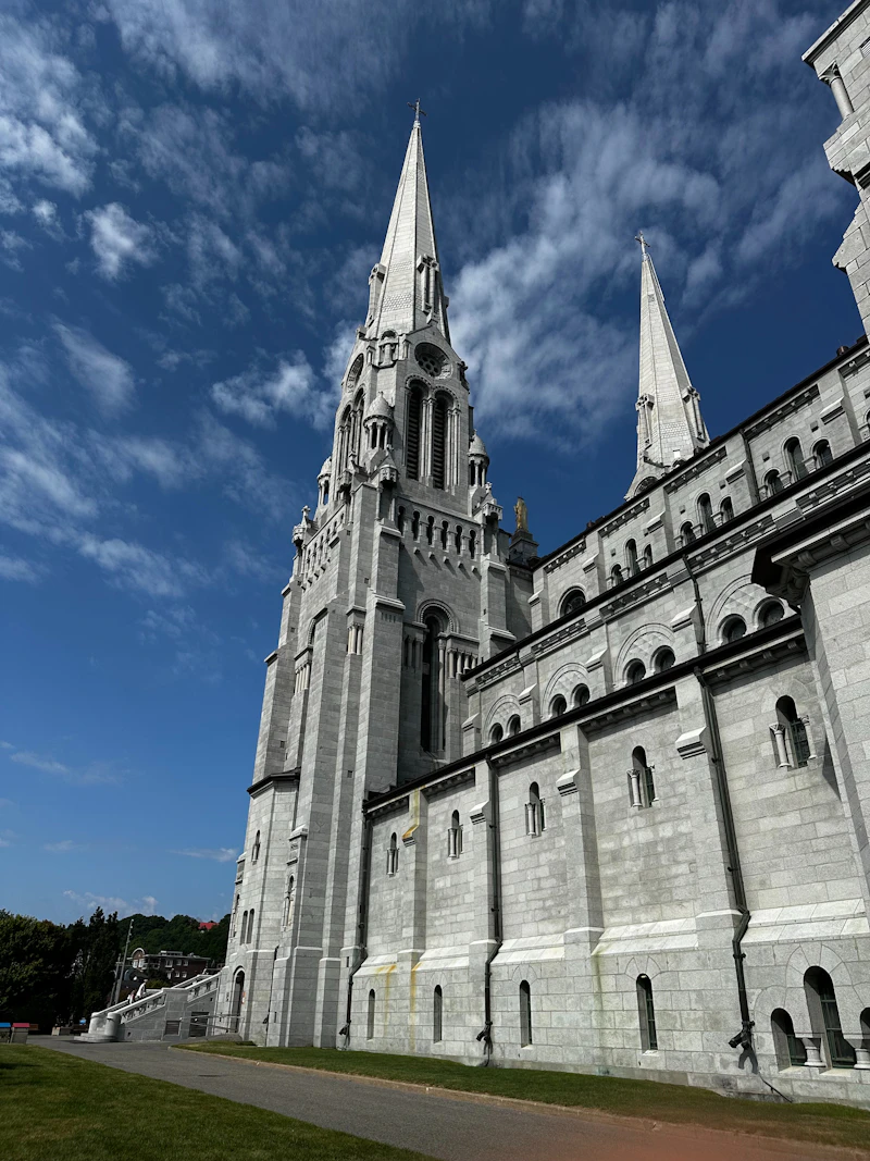 A white stone basilica with two tall spires against a deep blue sky