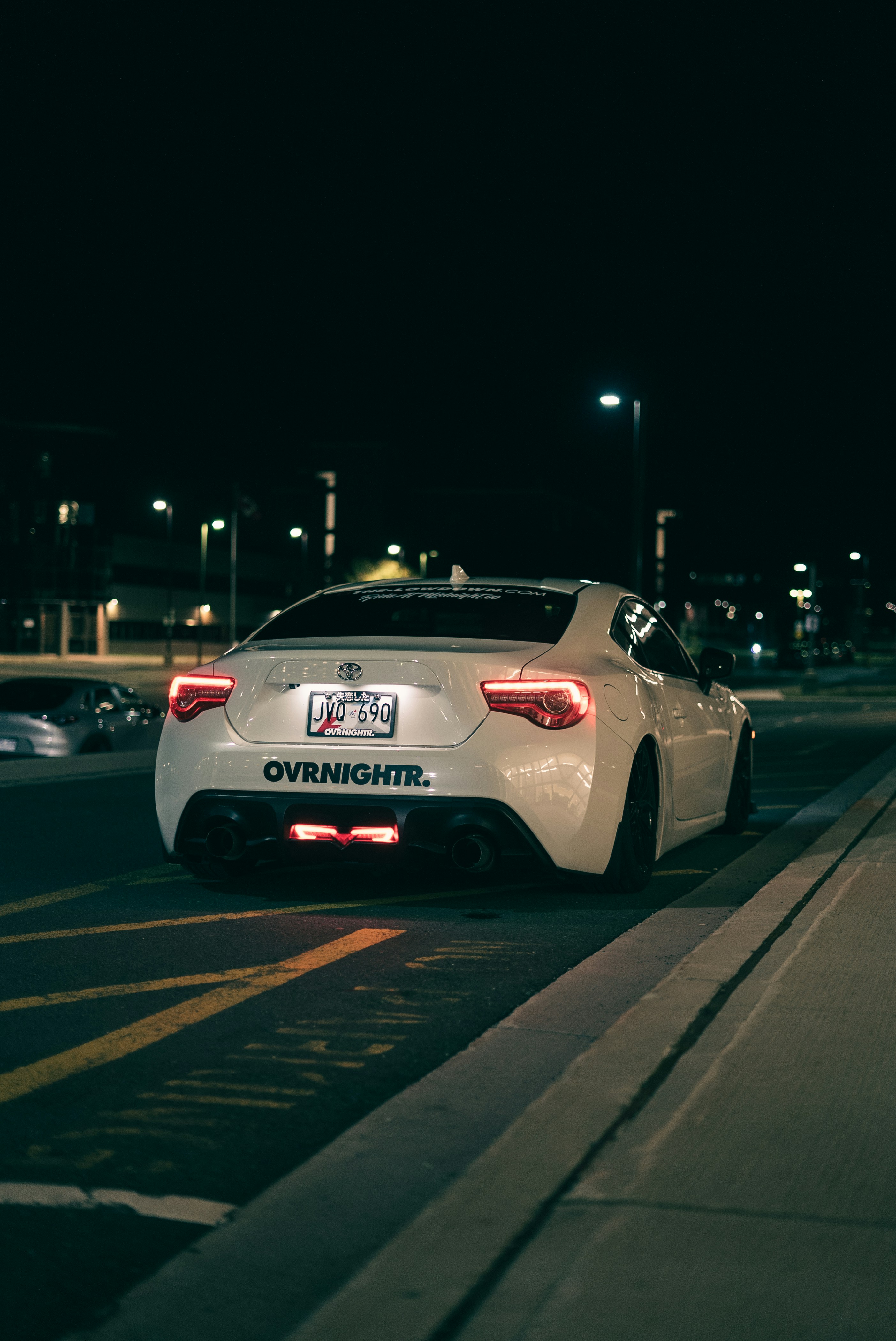 A white car driving down a street at night photo – Free Car Image on ...