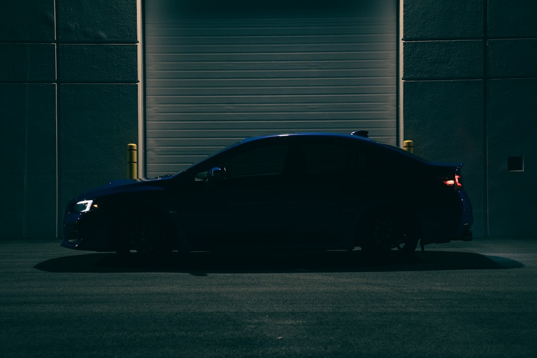 A car parked in front of a garage door,