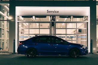 A blue car parked in front of a building
