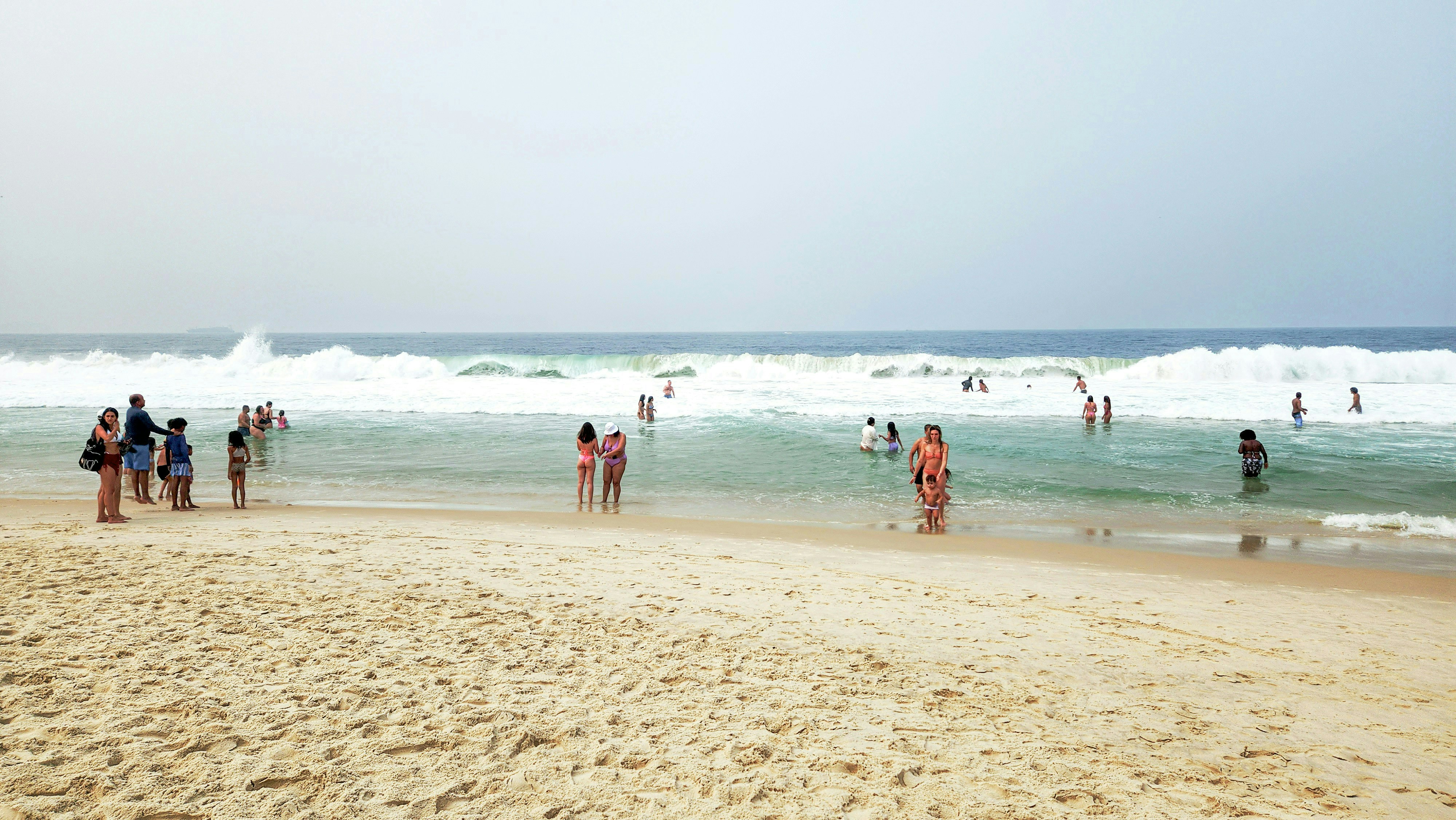 A group of people standing on top of a sandy beach