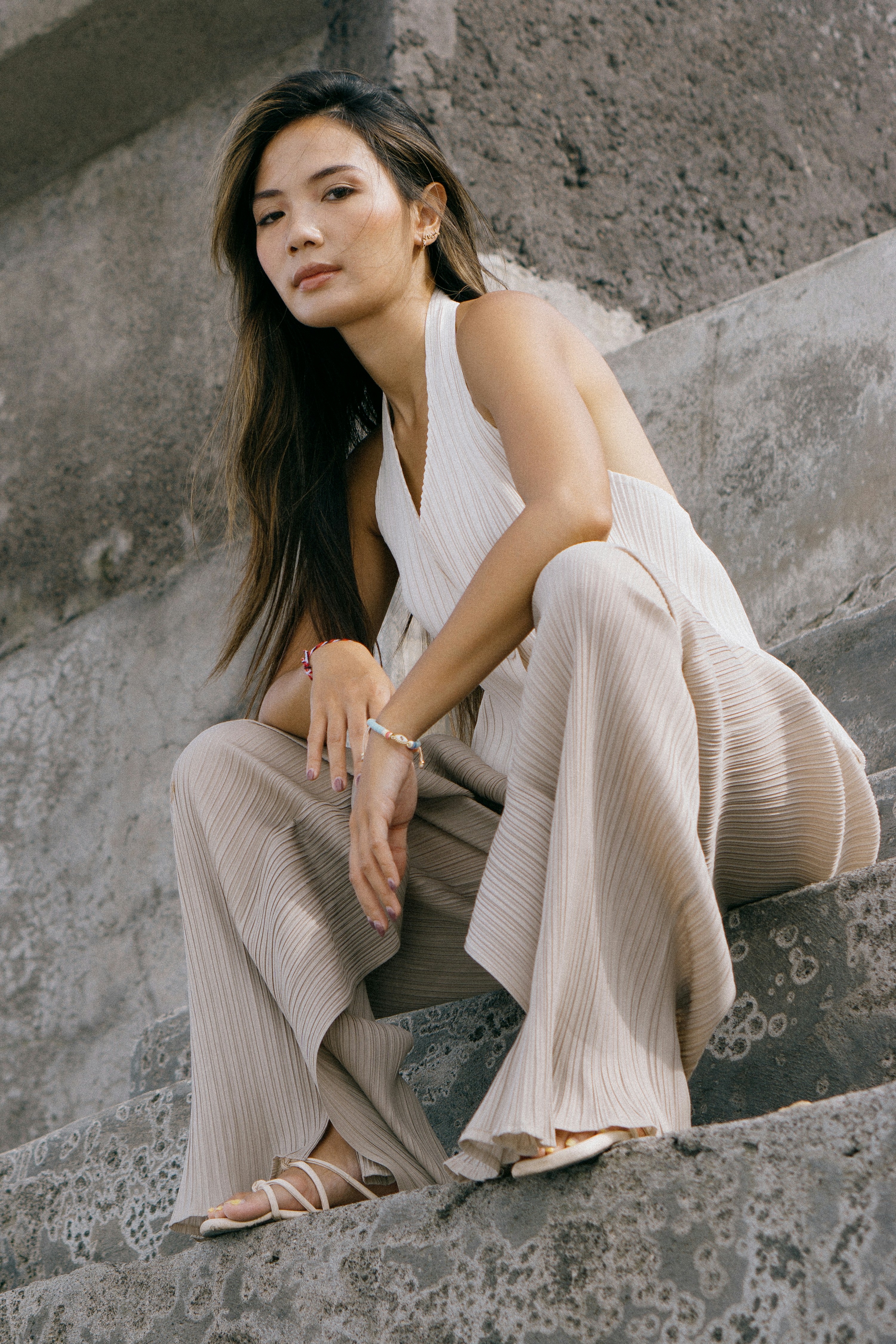 A woman is sitting on a stone ledge