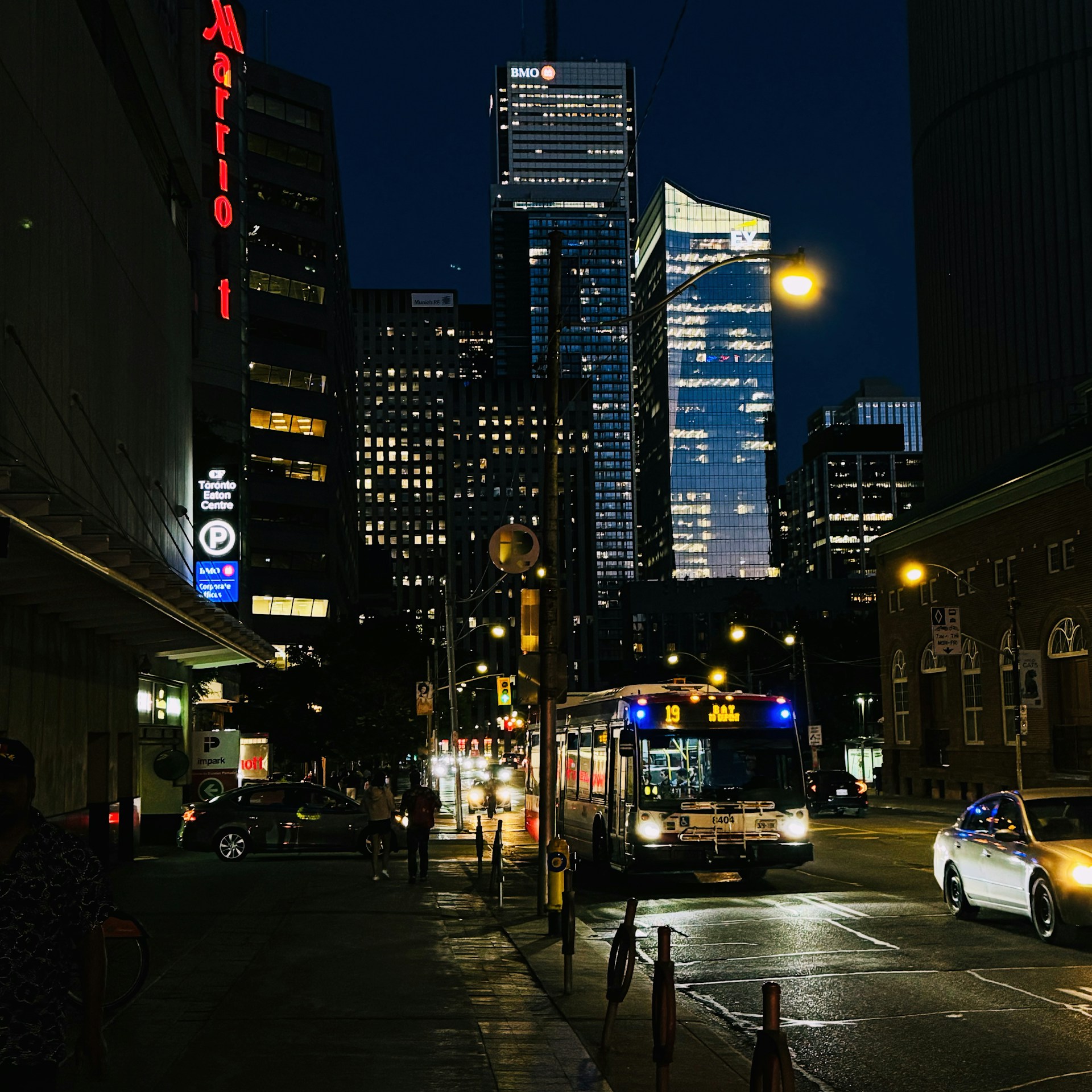 A city street at night with tall buildings