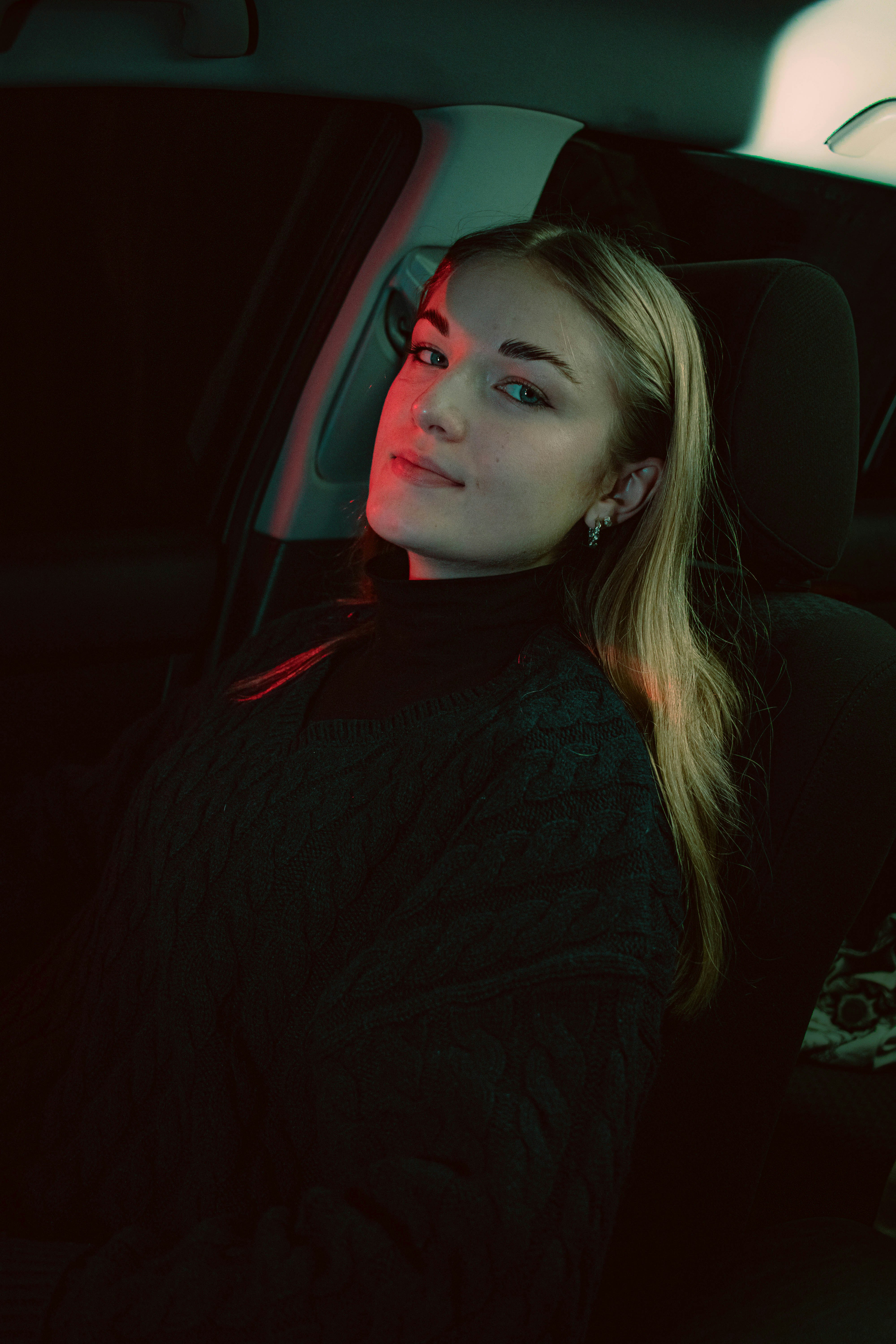 A woman sitting in the back seat of a car