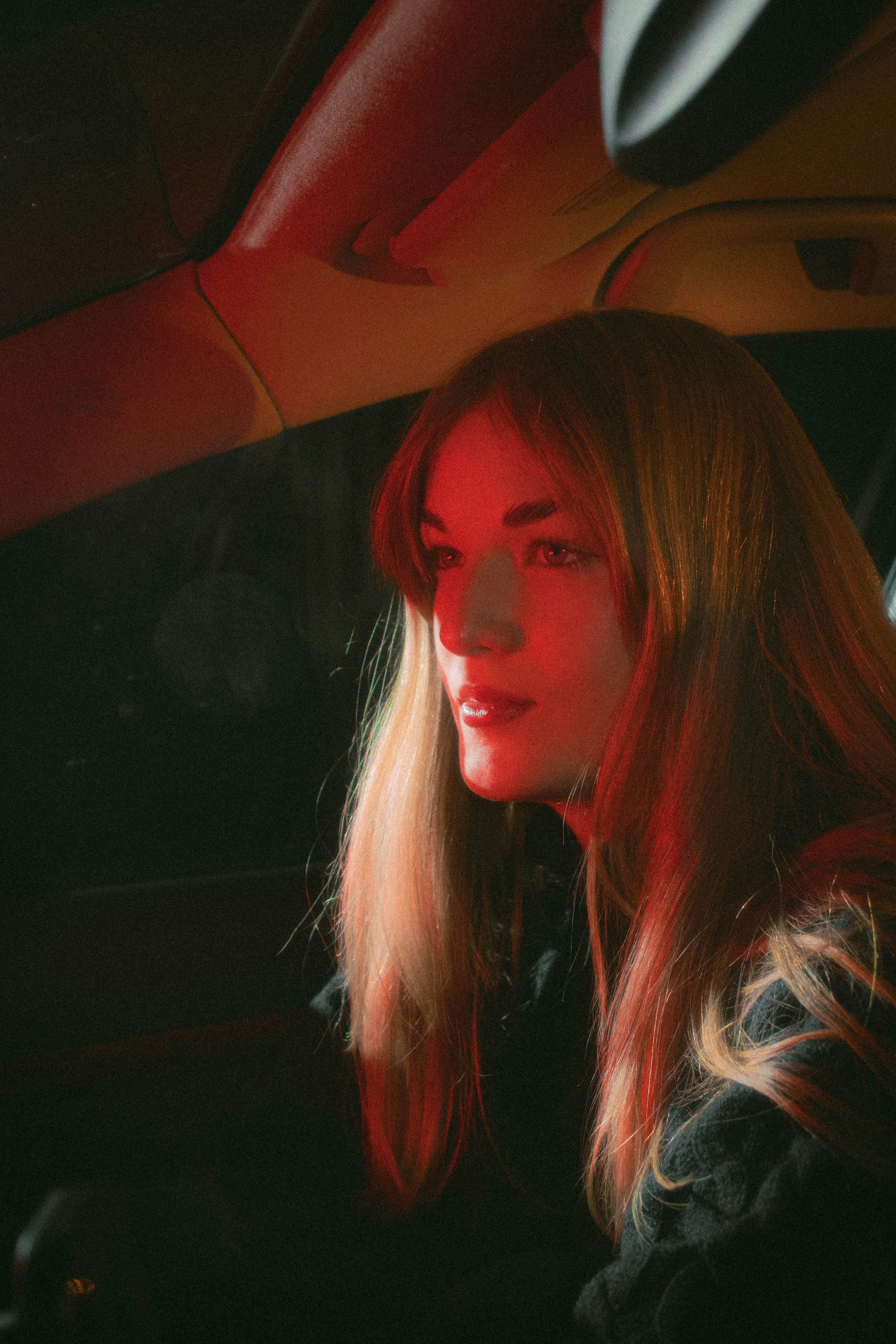 A woman sitting in a car with a cell phone in her hand
