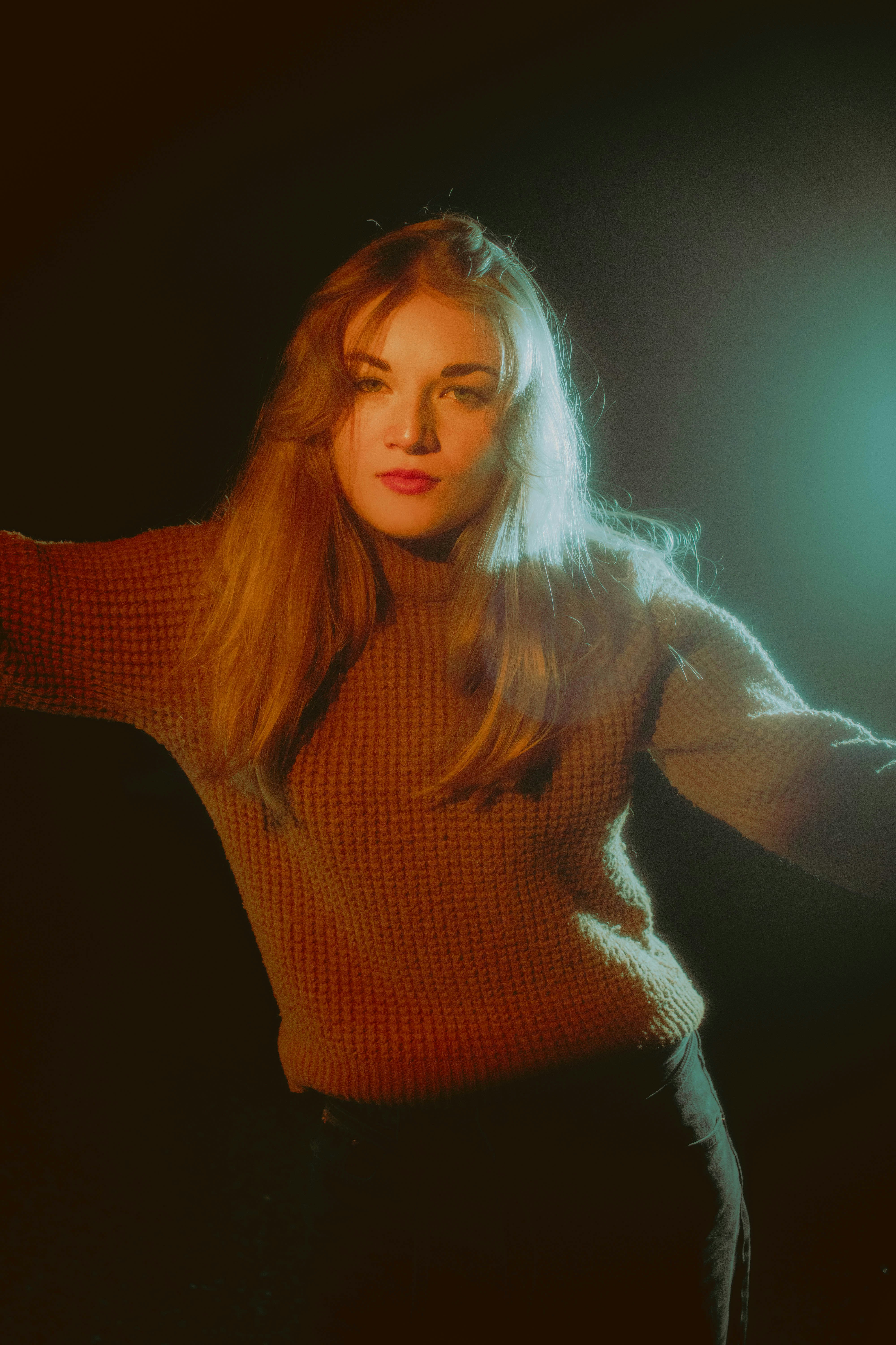 A woman in a brown sweater holding a white frisbee