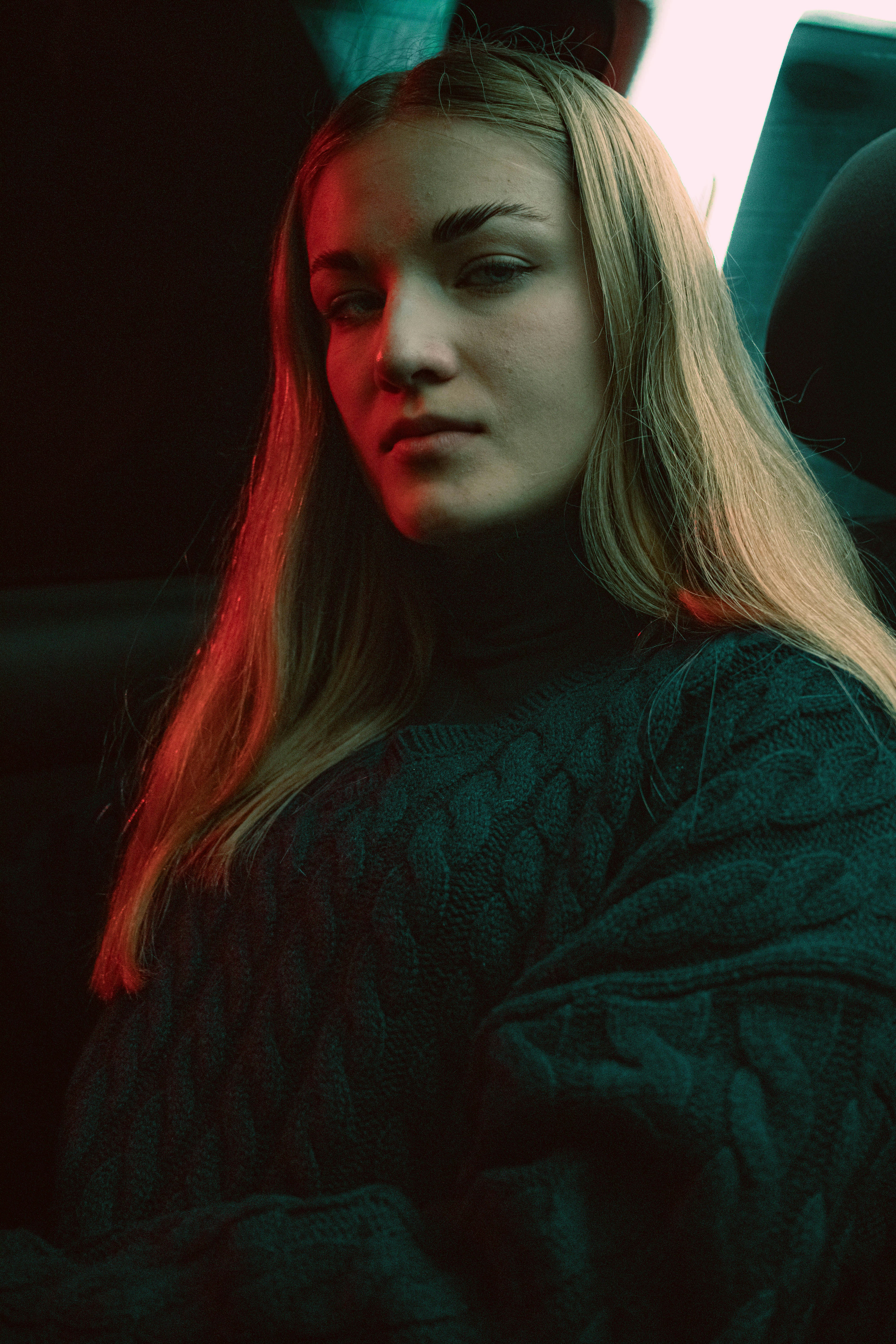A woman sitting in the back seat of a car