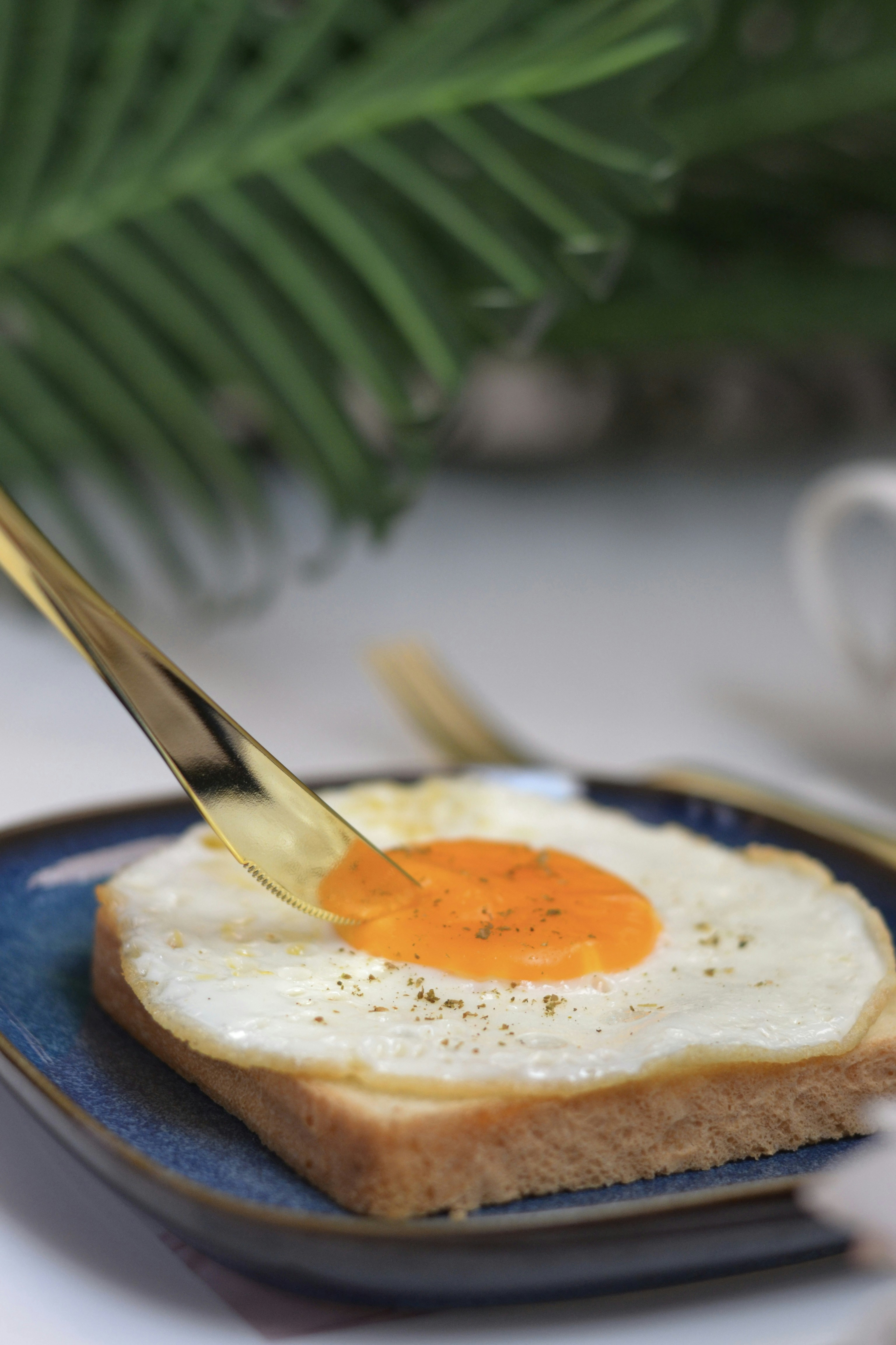 A person cutting a piece of bread with a knife
