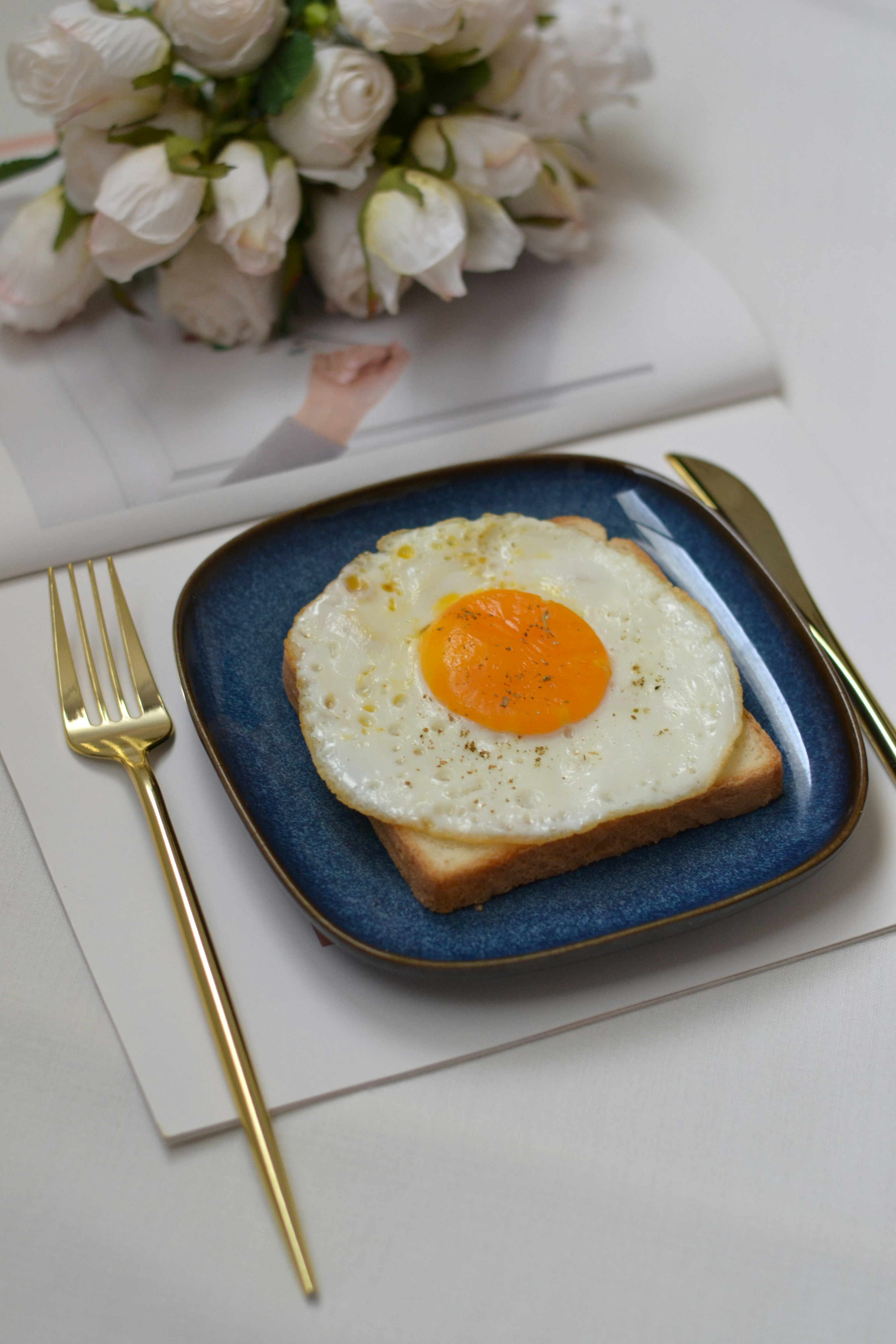 A blue plate topped with an egg on top of toast