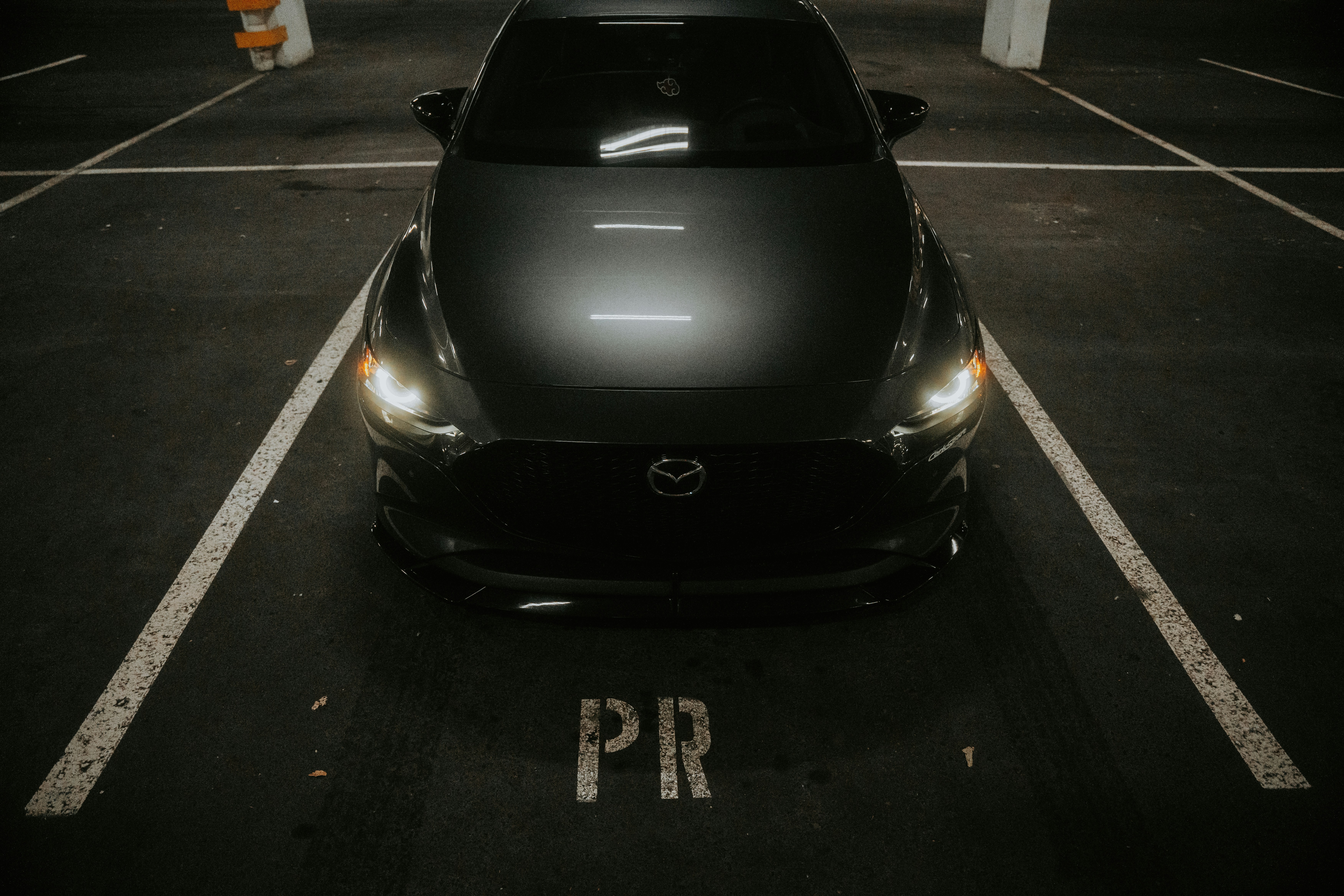 A car parked in a parking lot at night