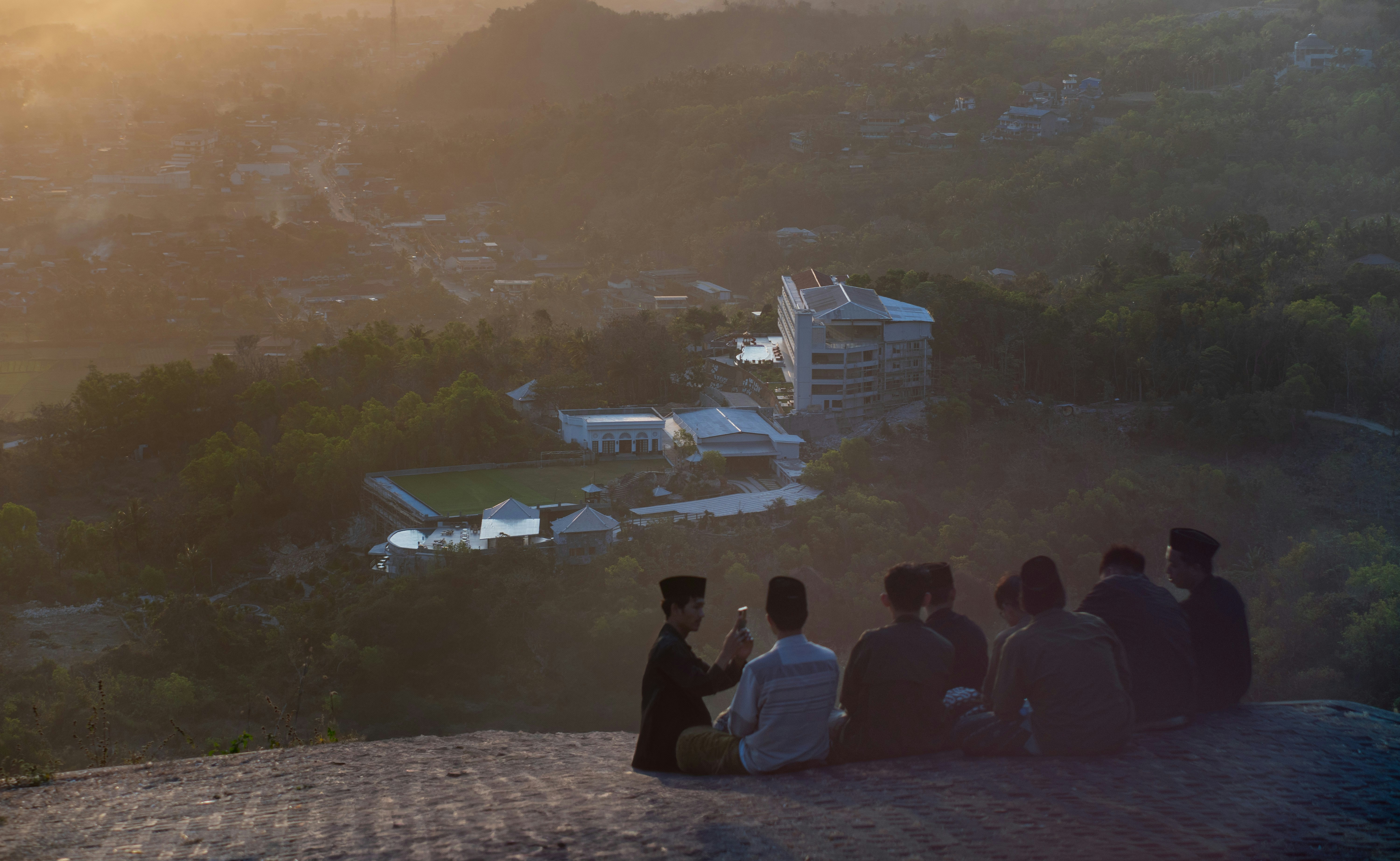 A group of people sitting on top of a hill