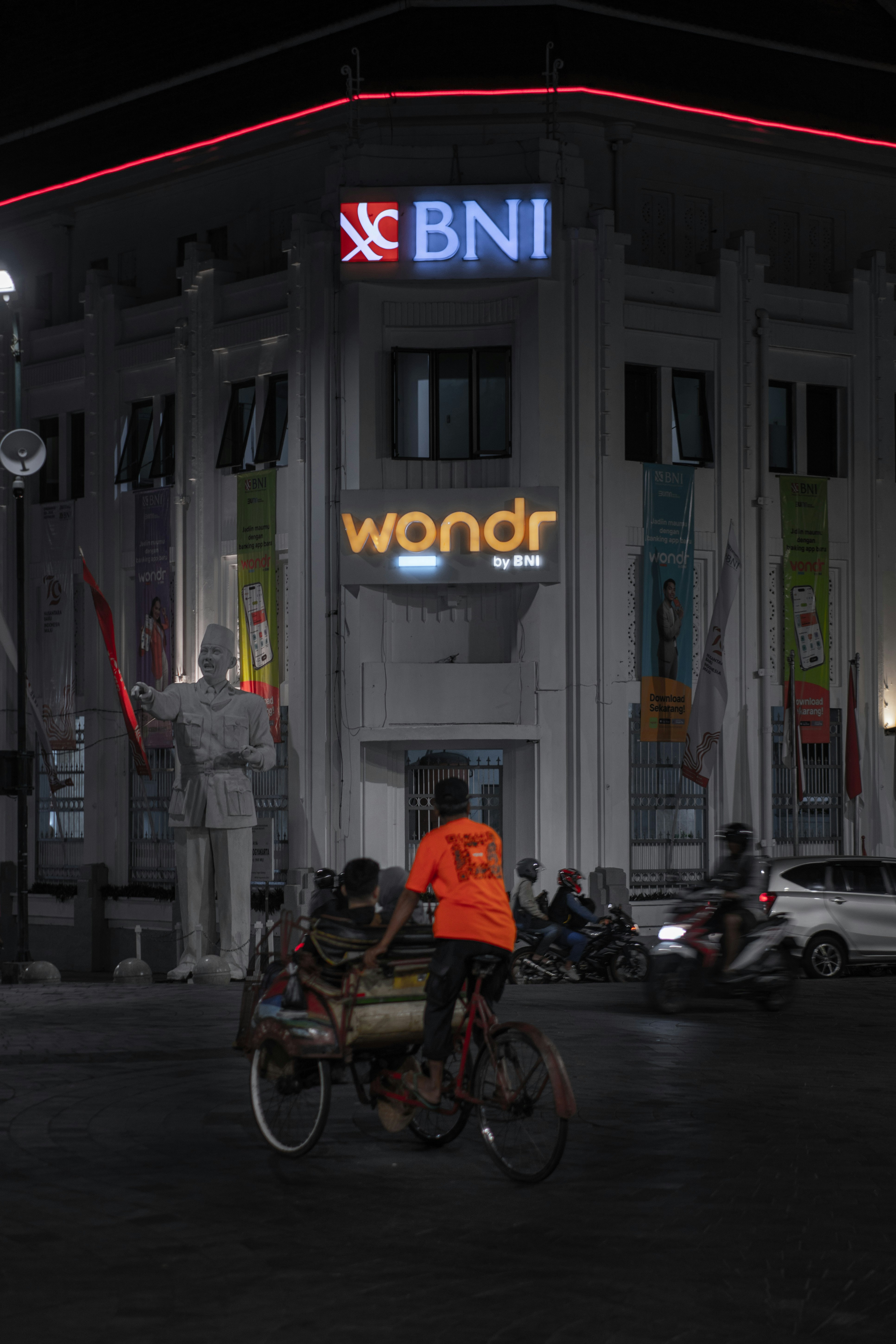 Un uomo in sella a una bicicletta davanti a un edificio