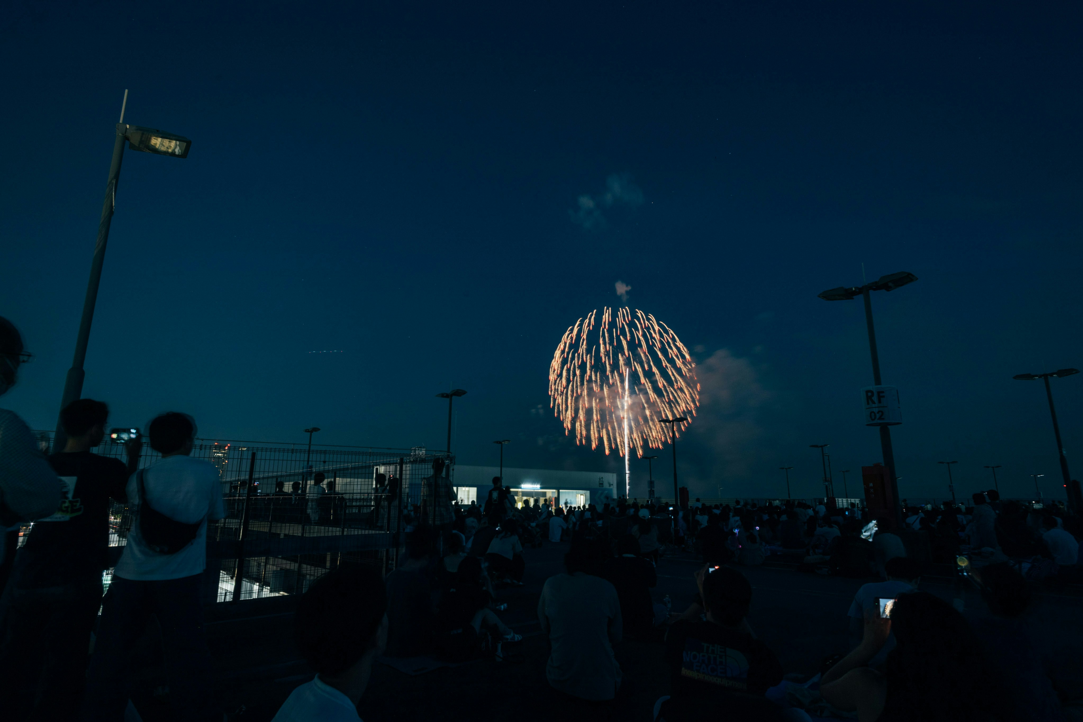 花火大会を見上げる観客のイメージ
