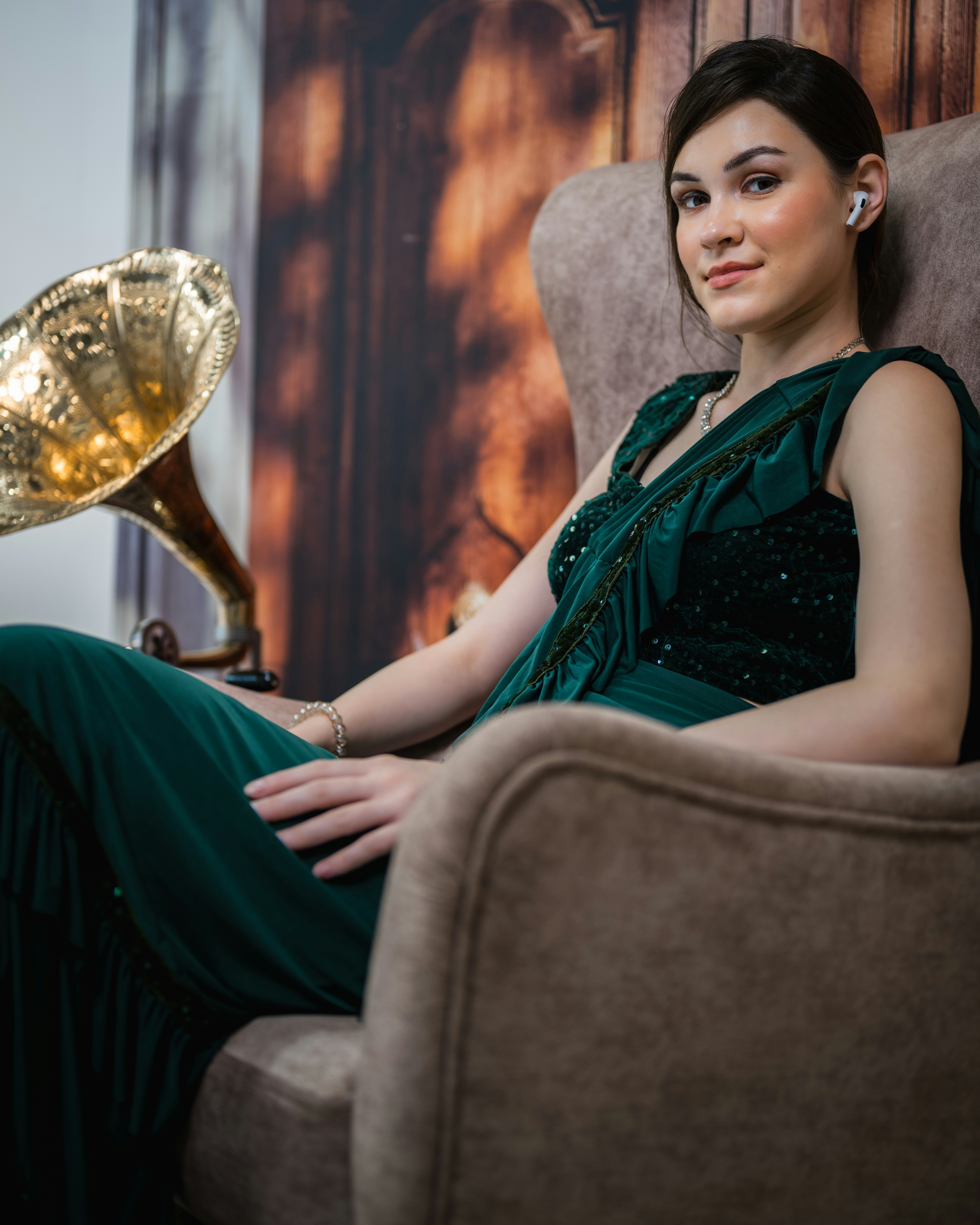 A woman in a green dress sitting in a chair