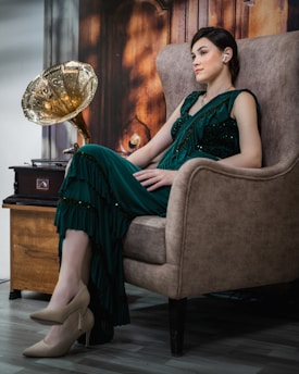 A woman in a green dress sitting in a chair