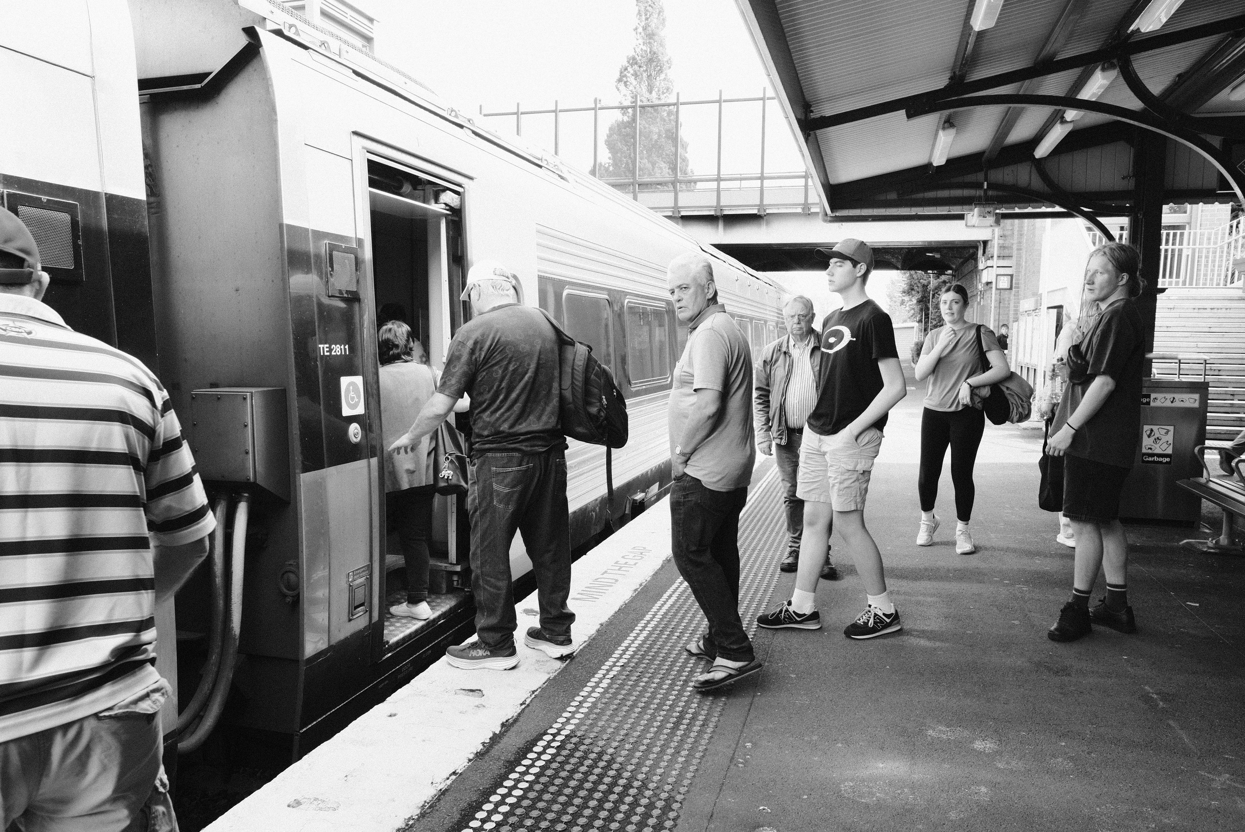 A group of people standing next to a train