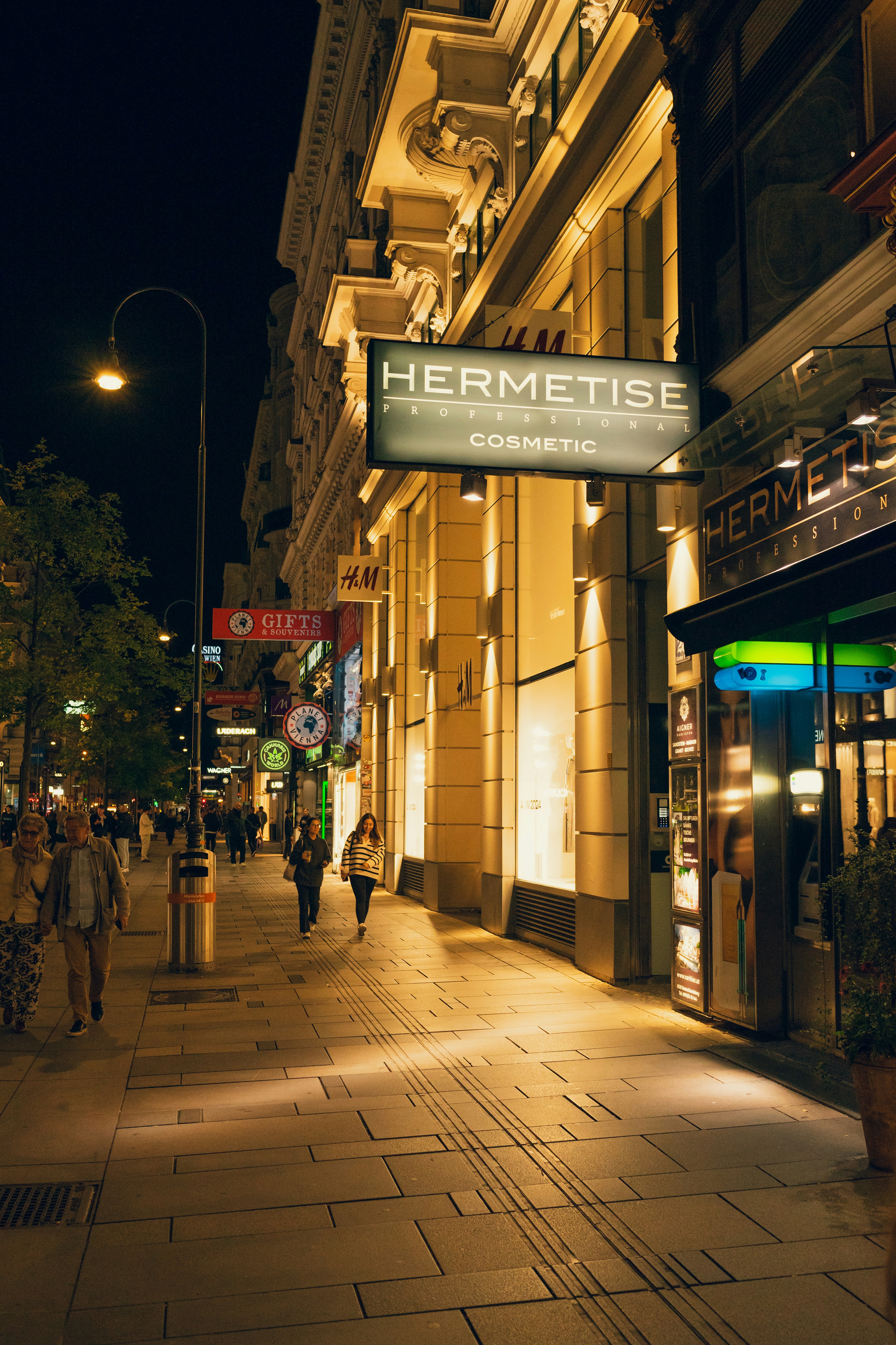 A city street at night with people walking on the sidewalk photo – Free ...