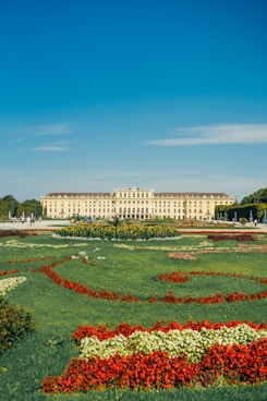 A large white building sitting next to a lush green field