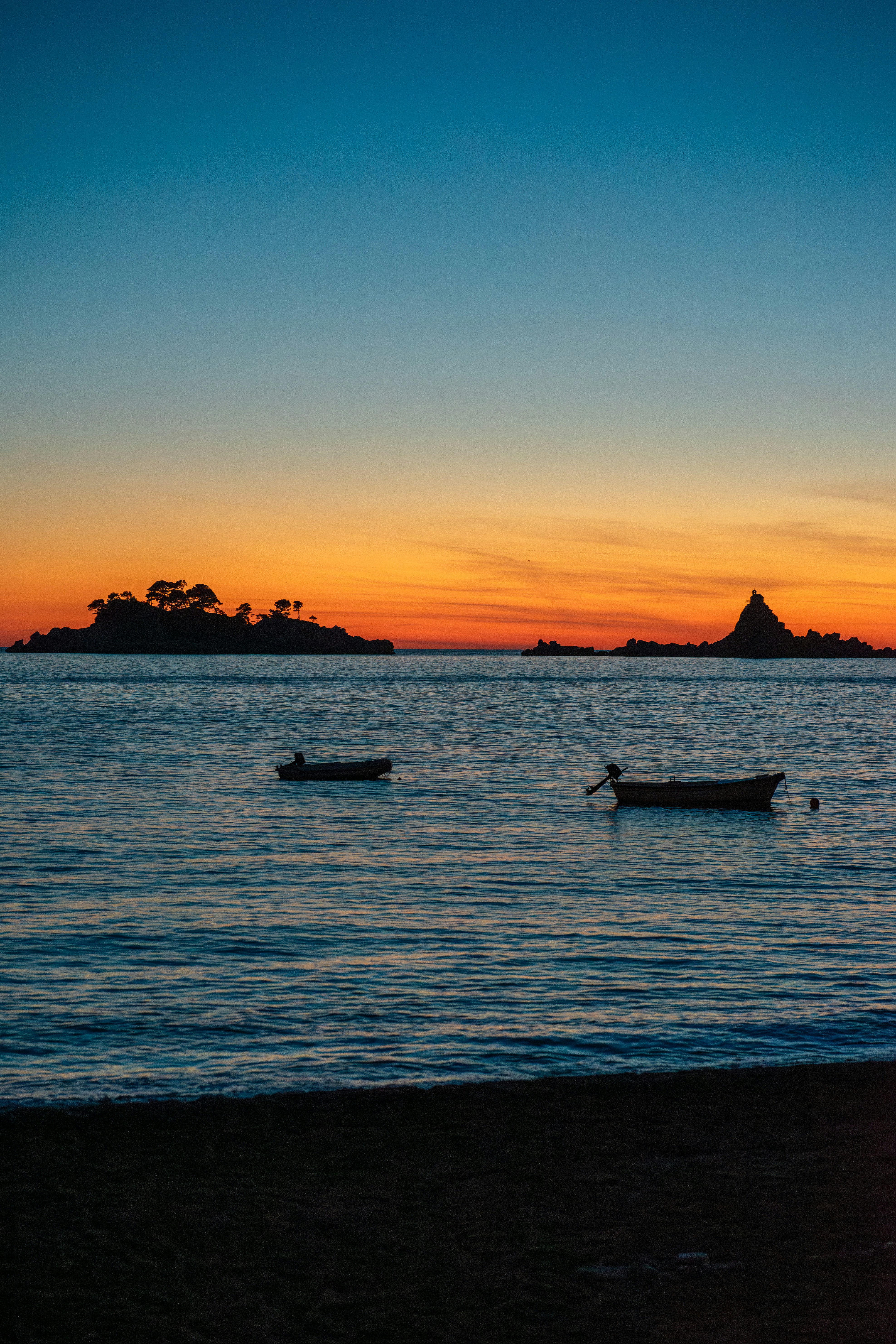 A couple of boats floating on top of a body of water photo – Free ...