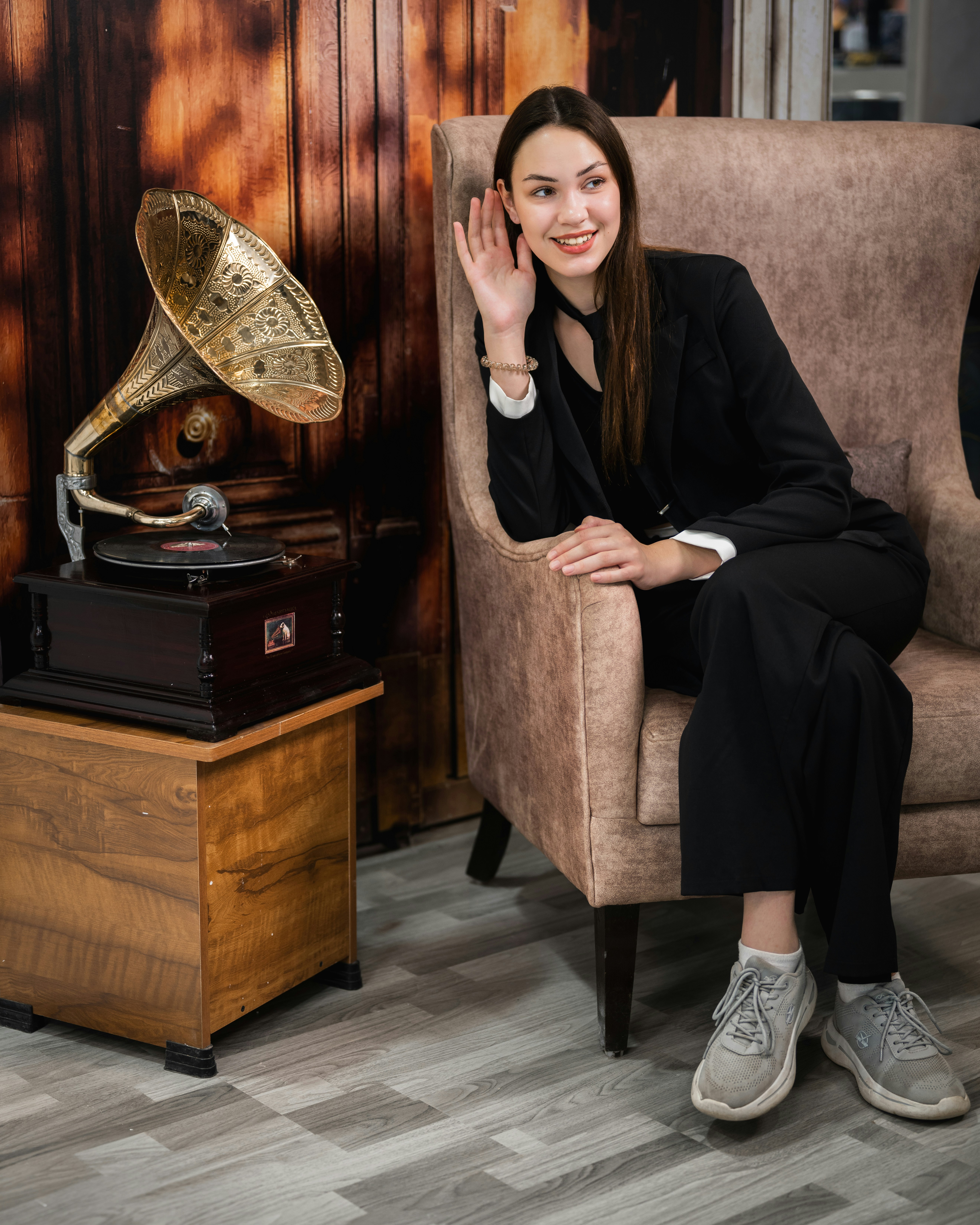A woman sitting in a chair next to a record player