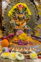 A statue with flowers and a candle on a table