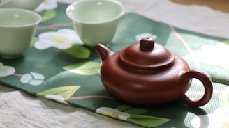 A tea pot and cups sitting on a table