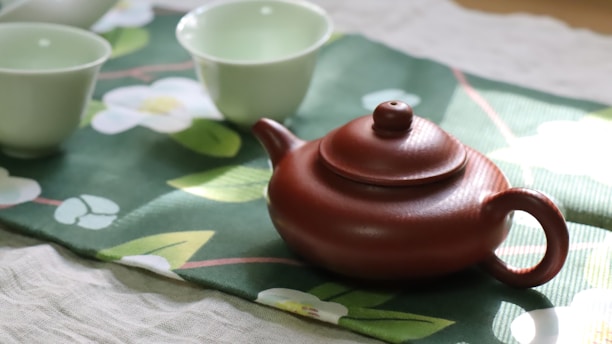 A tea pot and cups sitting on a table