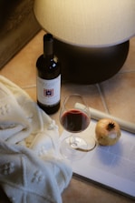 A bottle of wine and a glass of wine on a table