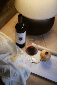 A bottle of wine and a glass of wine on a table