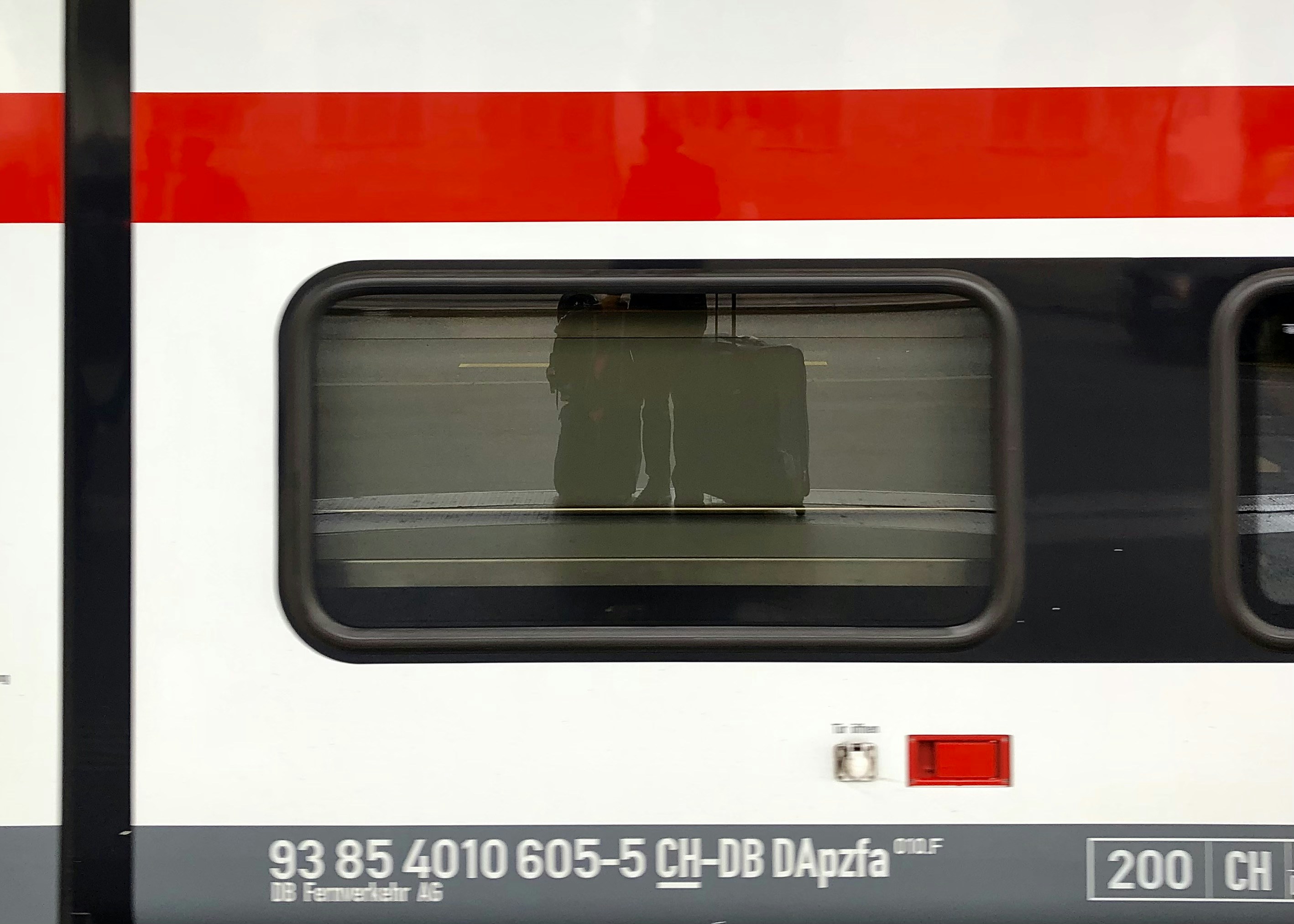 A close up of a train window with a red stripe, 