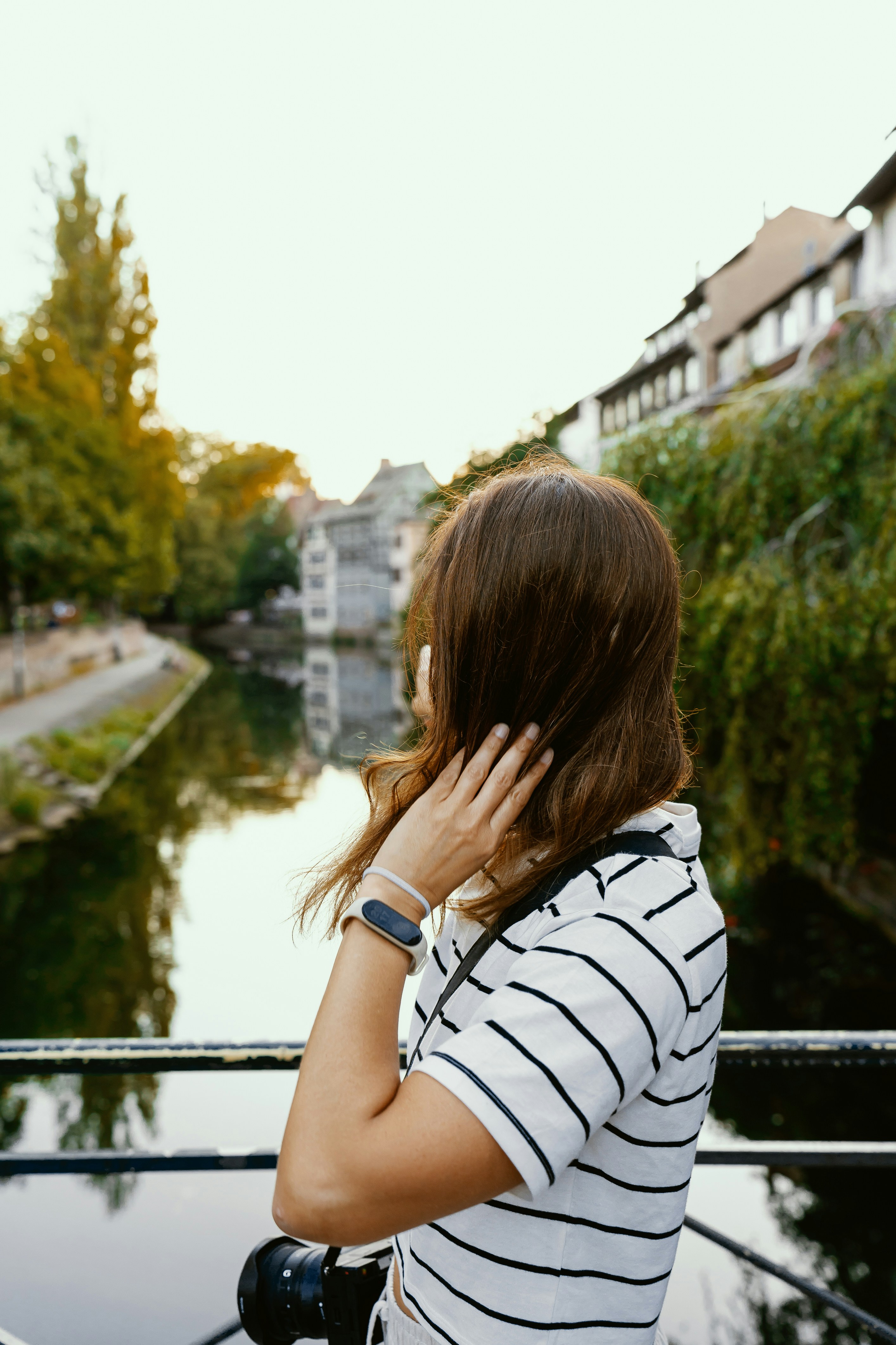 A woman talking on a cell phone next to a river