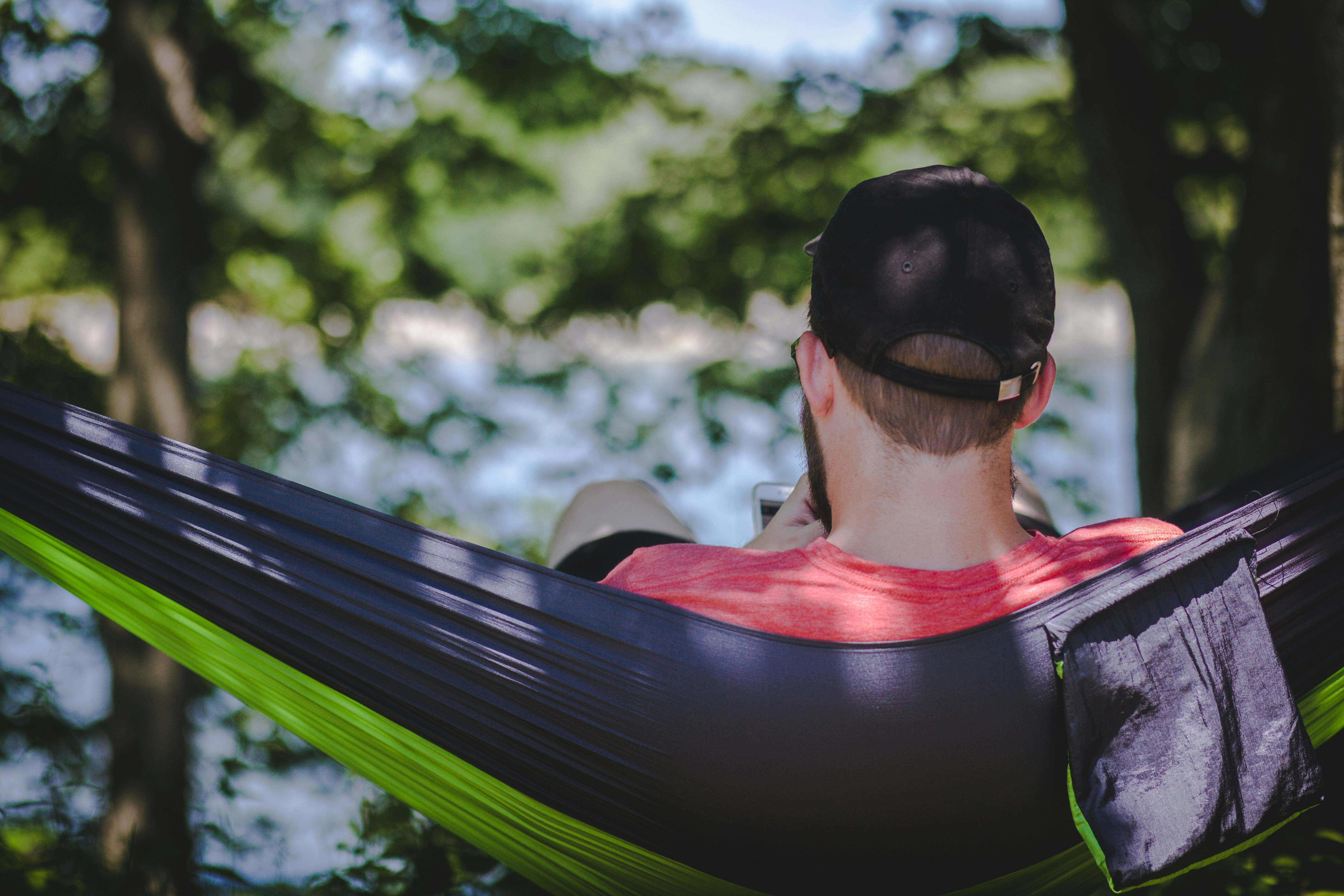 Ein Mann sitzt in einer Hängematte im Wald