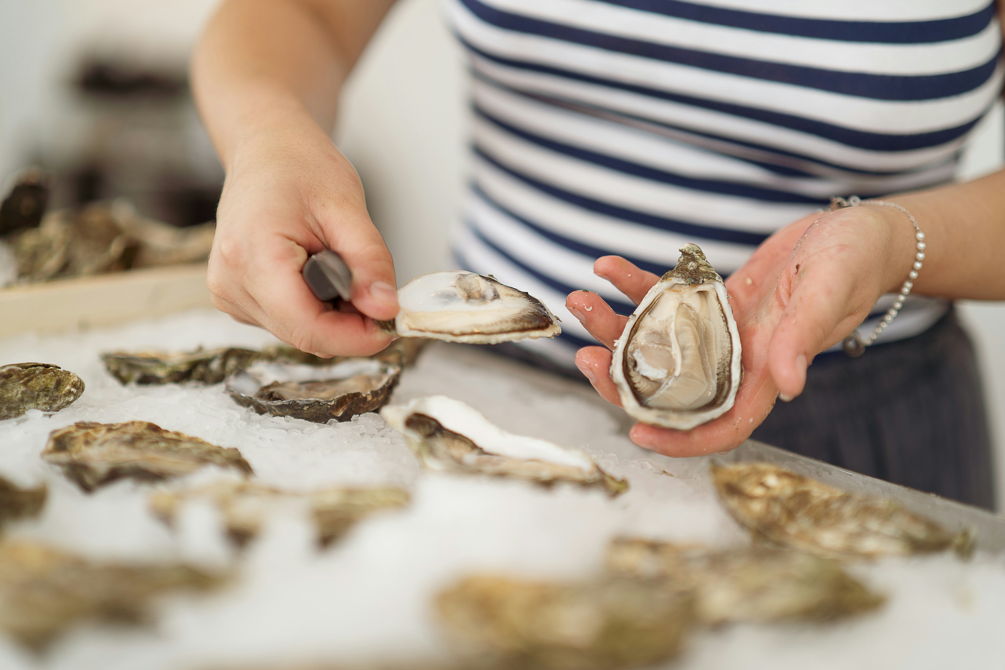 Woman holding a freshly opened oyster