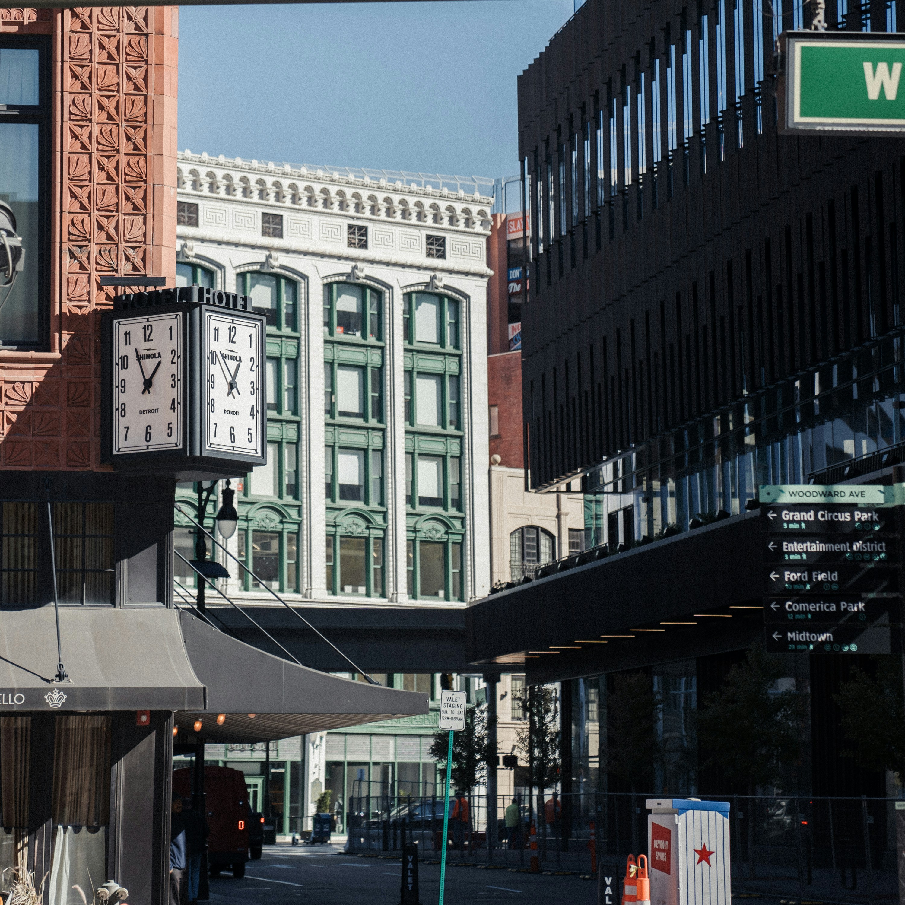 A city street with tall buildings and a clock tower