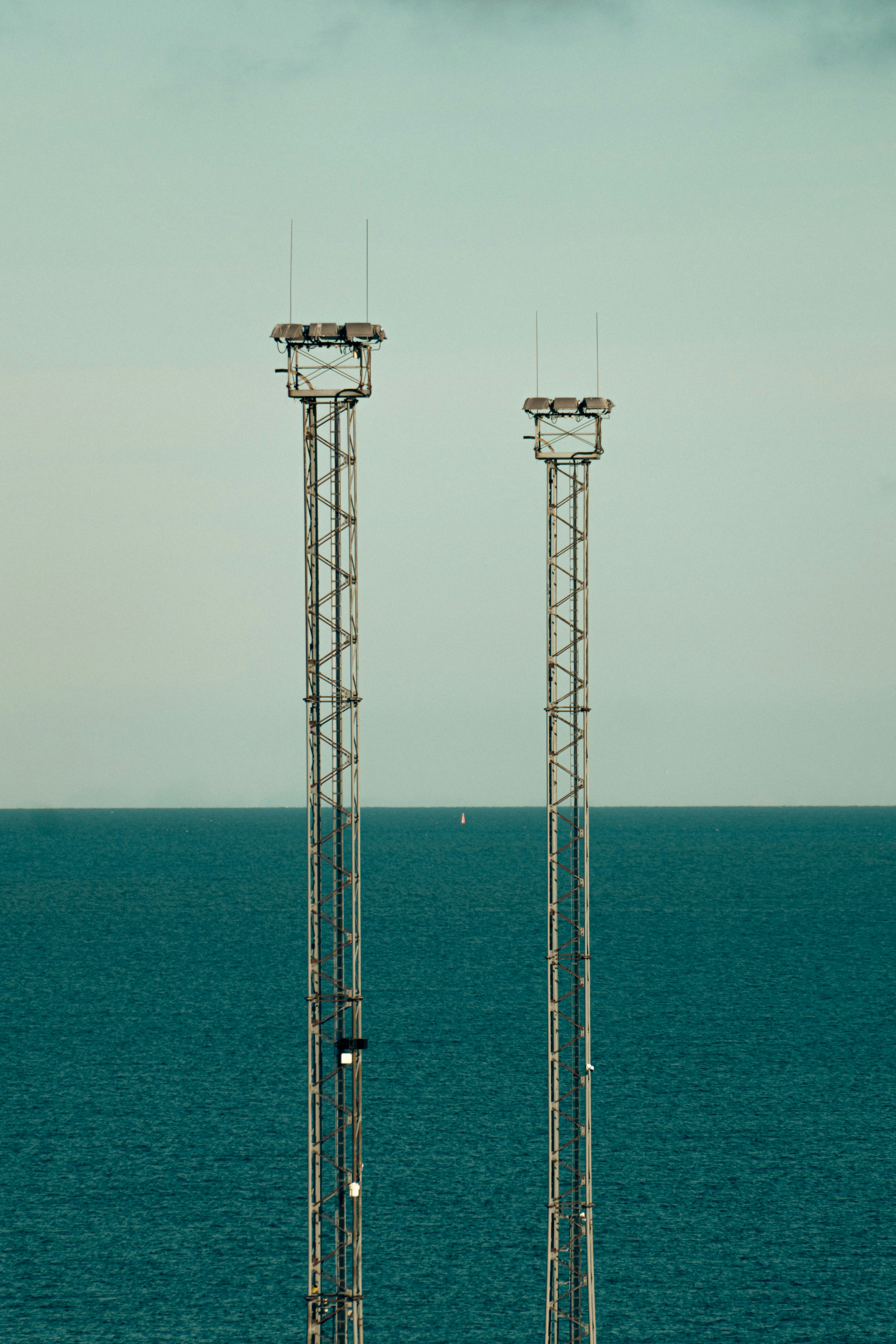 A couple of cell towers sitting in the middle of the ocean
