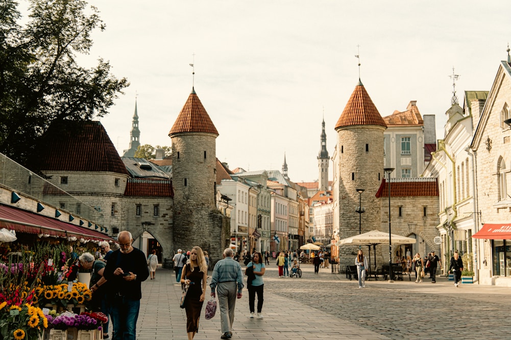 A group of people walking down a street next to tall buildings