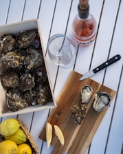 A box of oysters next to a bottle of wine