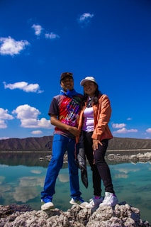 A couple of people standing on top of a rock