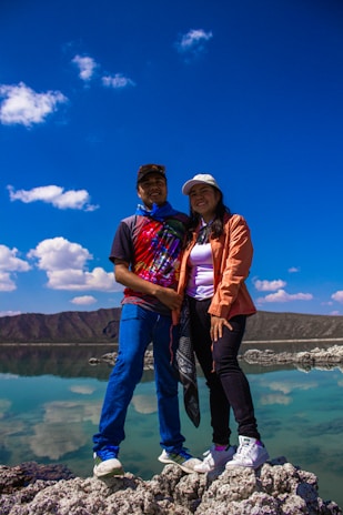 A couple of people standing on top of a rock