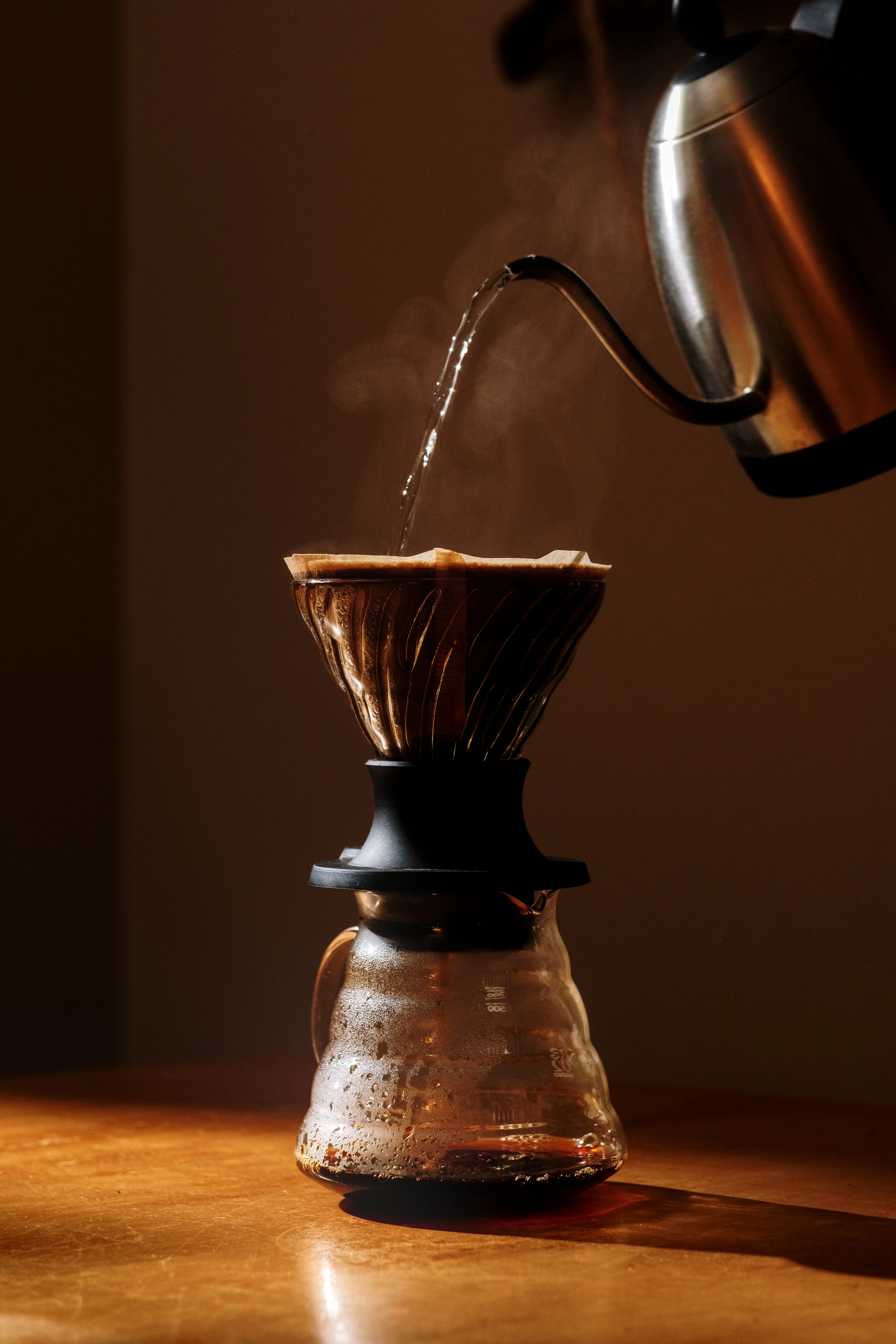 Kettle pouring water over a pour-over brewer