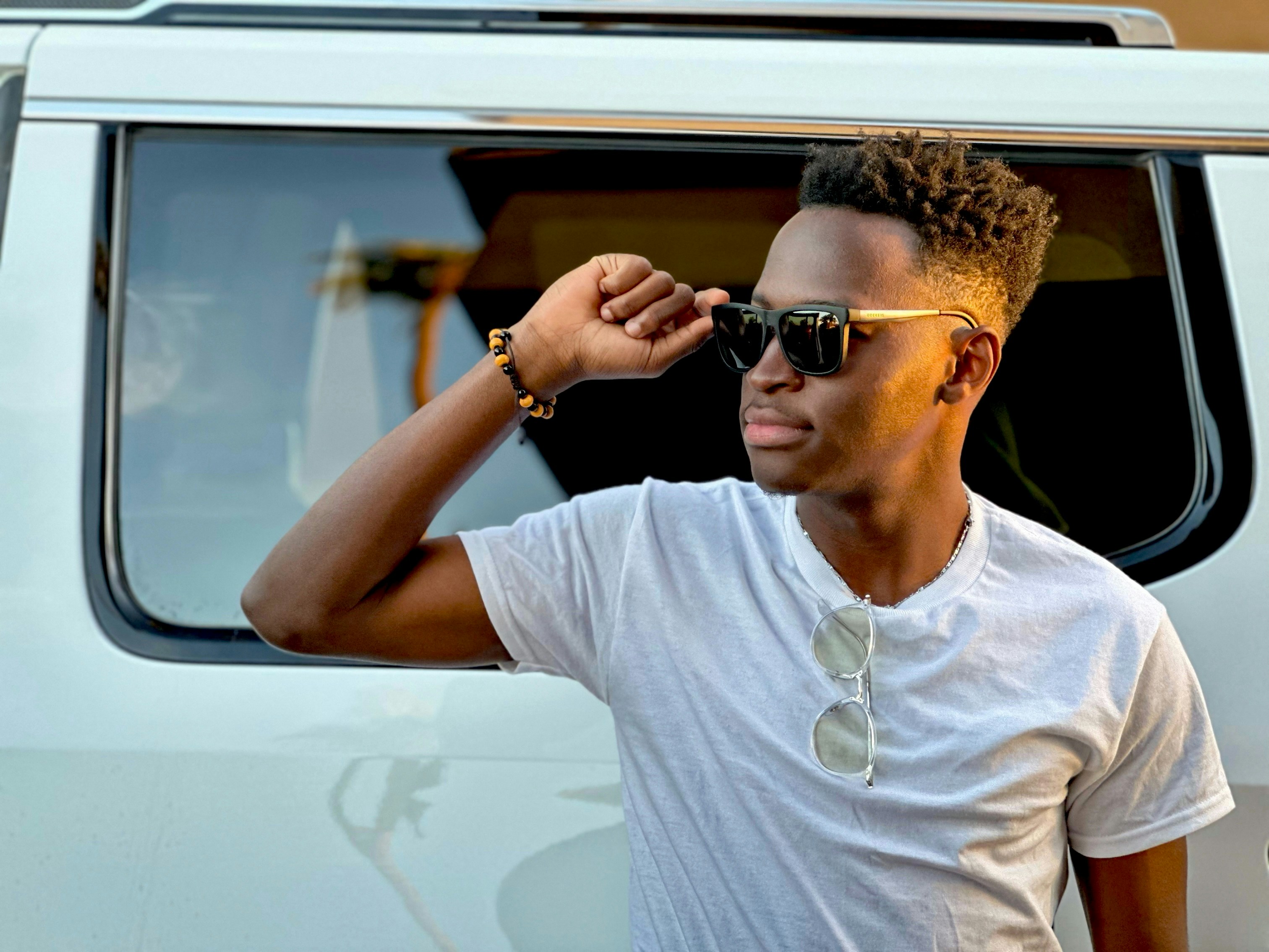 A man in a white shirt is looking out the window of a van