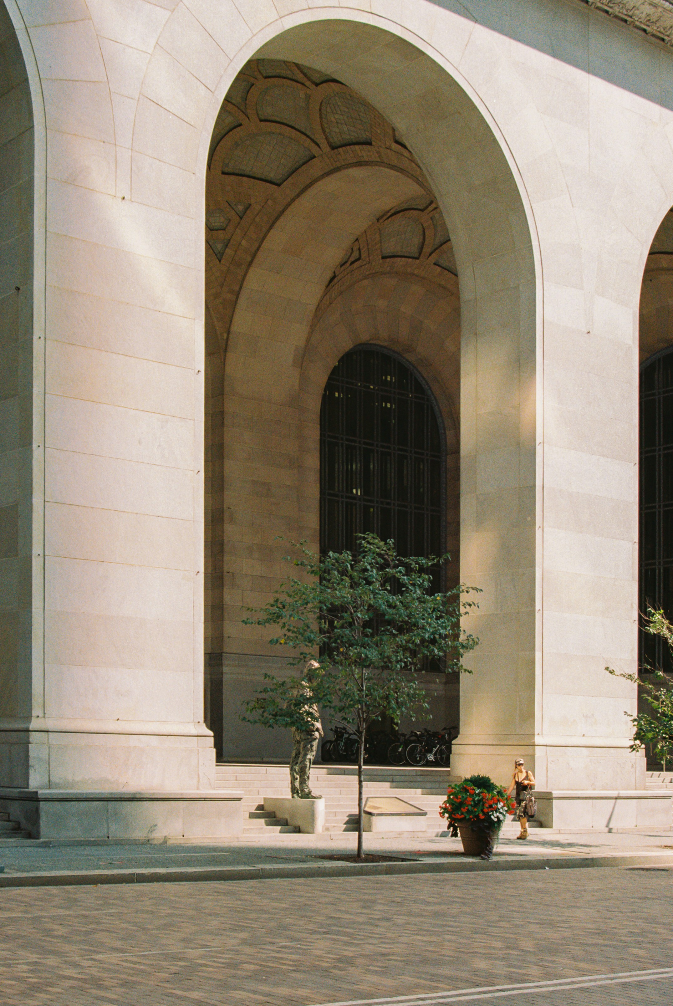 Ein Mann fährt mit einem Skateboard eine Straße neben einem hohen Gebäude hinunter