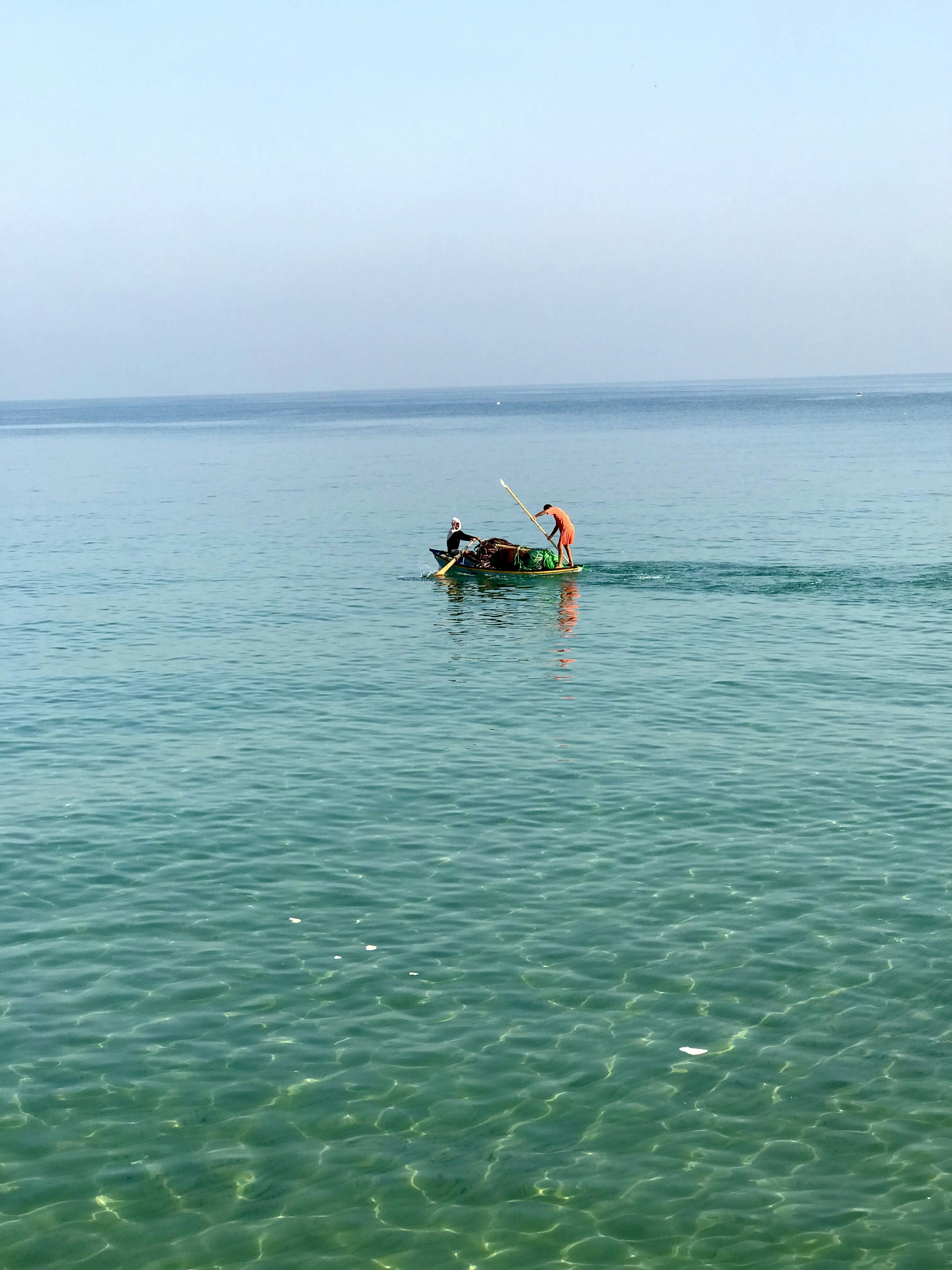 水中の小さなボートに乗った2人