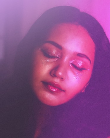 A woman with her eyes closed in a dark room