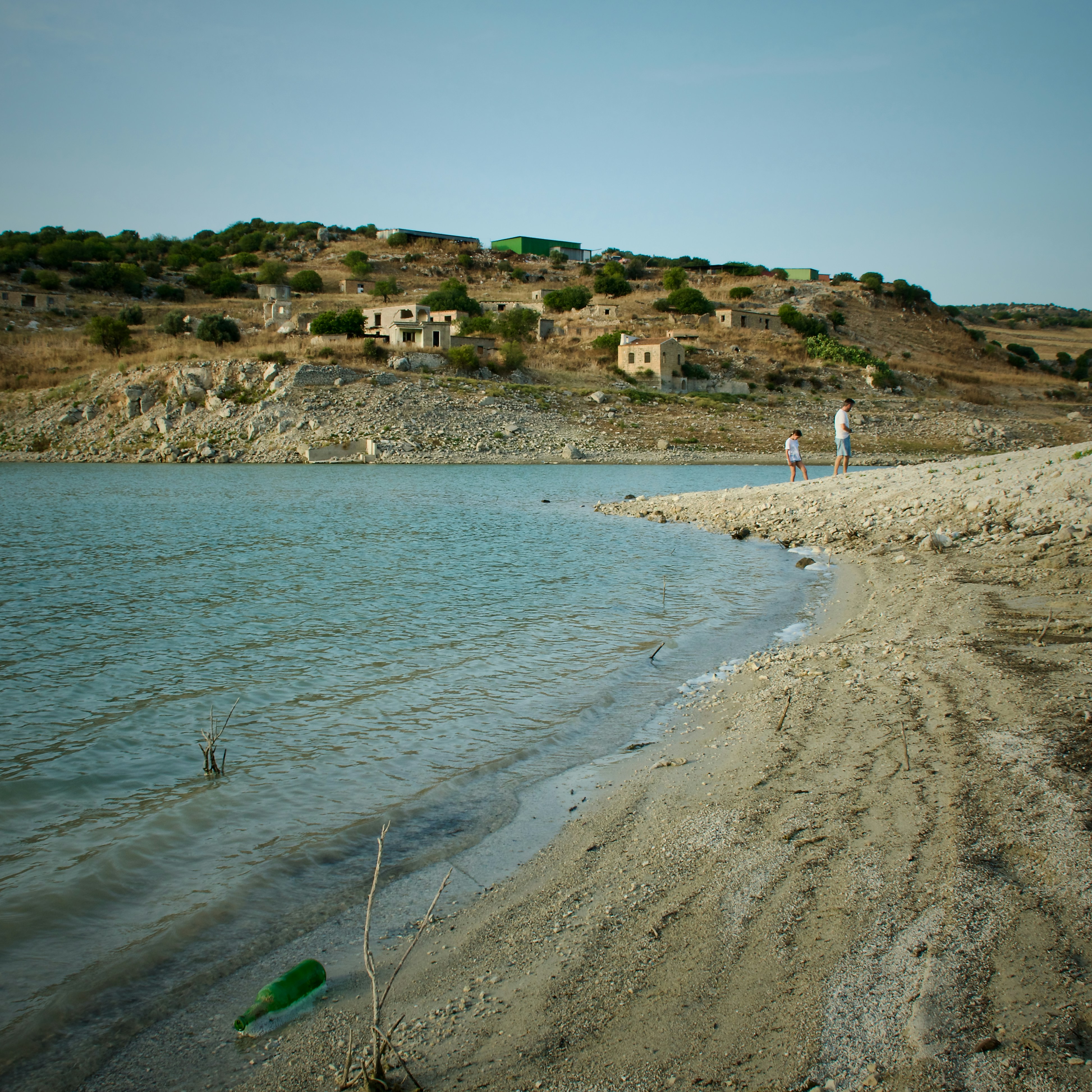 A body of water with a hill in the background